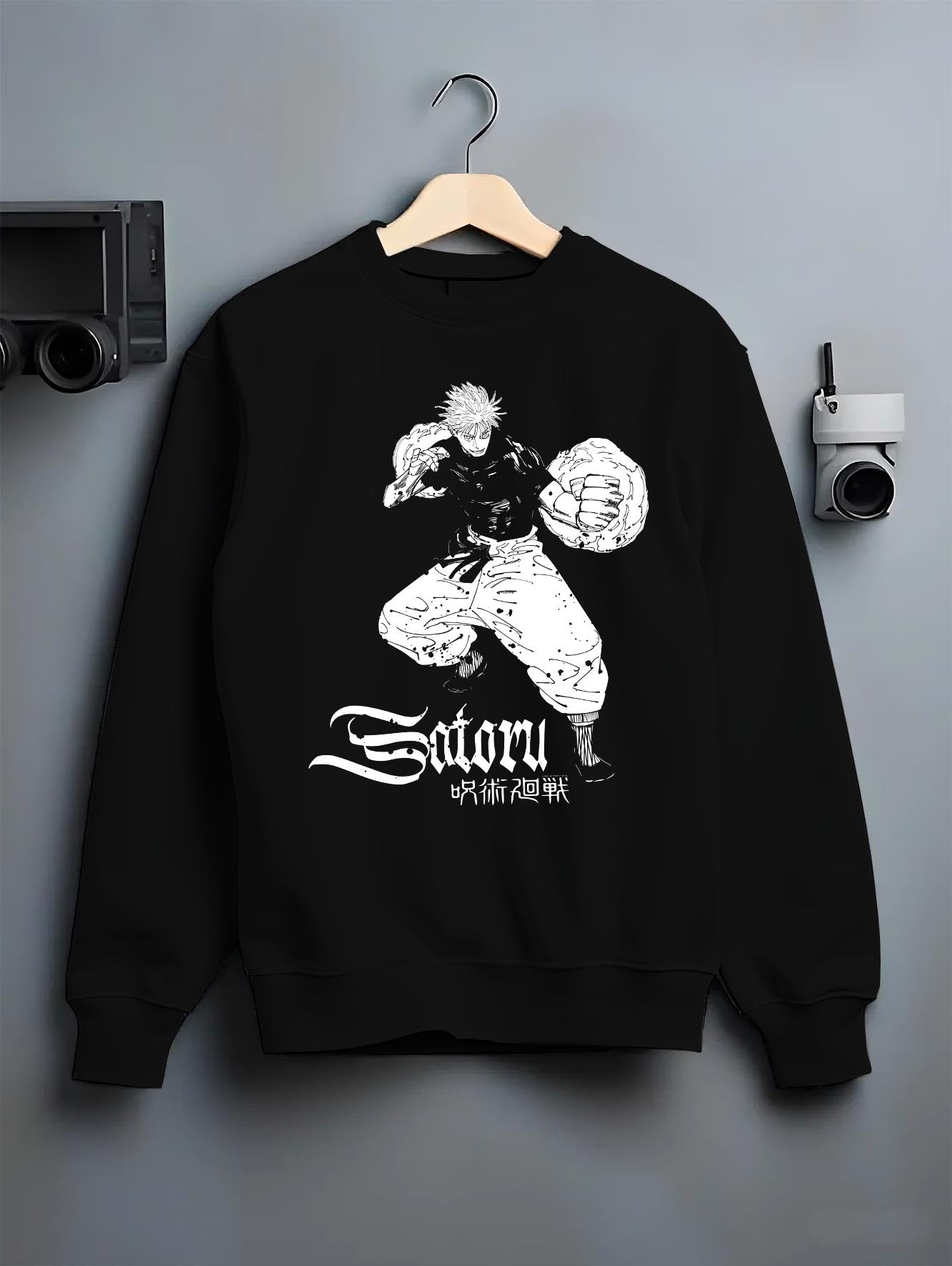 Black crewneck sweatshirt on a hanger against a grey wall, featuring anime poster inspired design of Satoru with strong fighting stance artwork.
