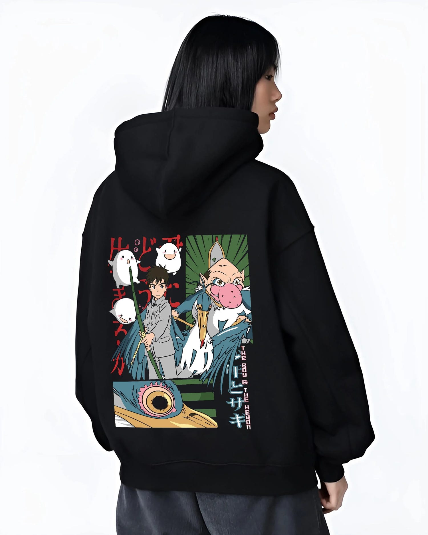 Black hoodie worn by female model, back view with The Boy And The Heron Hoodie Studio Ghibli Movie graphic bold anime graphic.