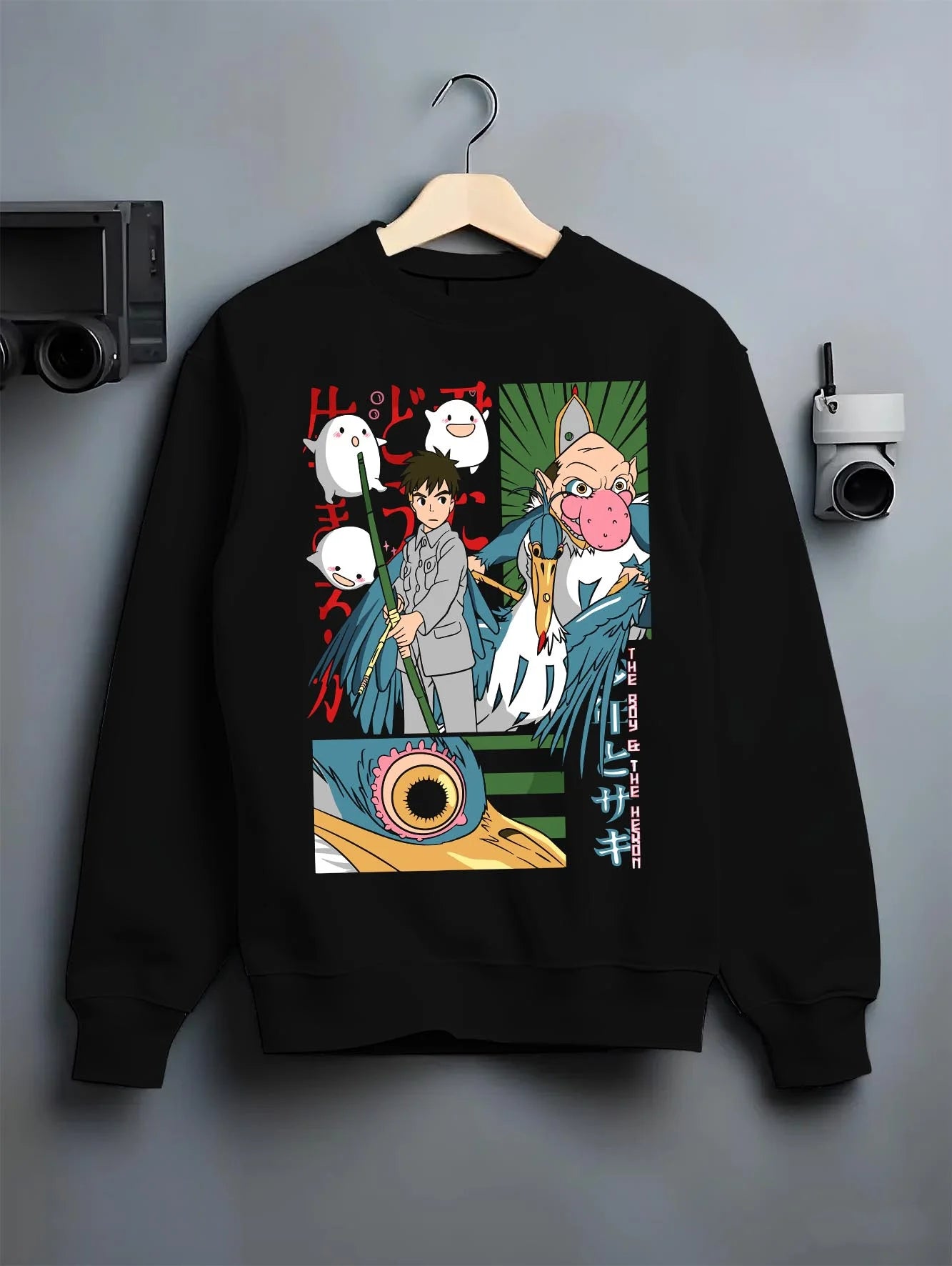Black crewneck sweatshirt on hanger with The Boy And The Heron Hoodie Studio Ghibli Movie graphic nan anime design.