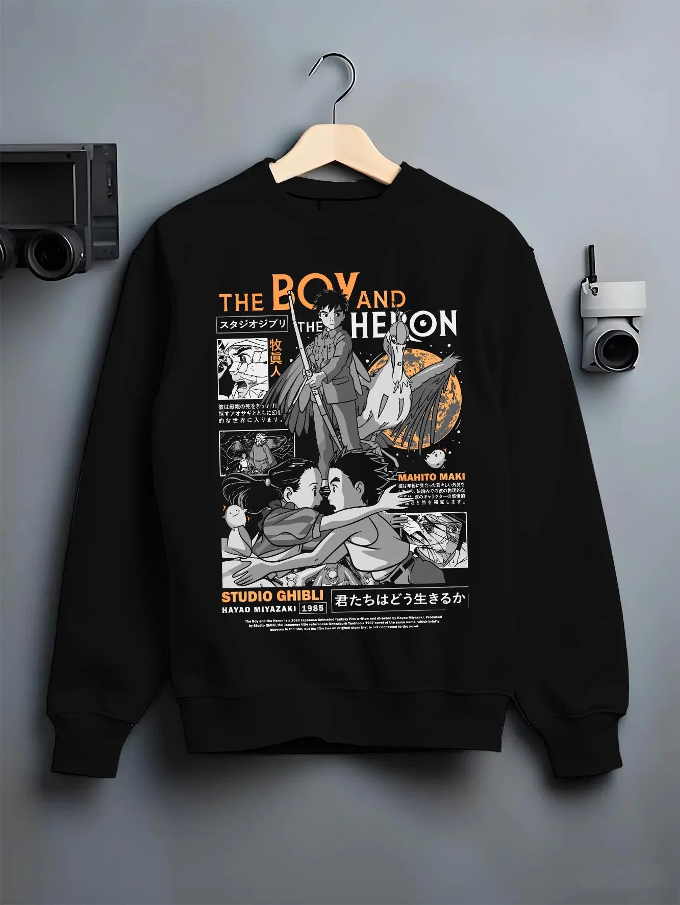 Black crewneck sweatshirt on hanger with The Boy And The Heron Hoodie Studio Ghibli Cover graphic nan anime design.