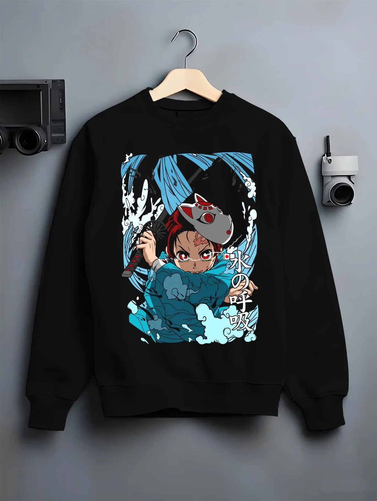 Black crewneck sweatshirt on hanger featuring Tanjiro Hinokami flame and water breathing artwork.