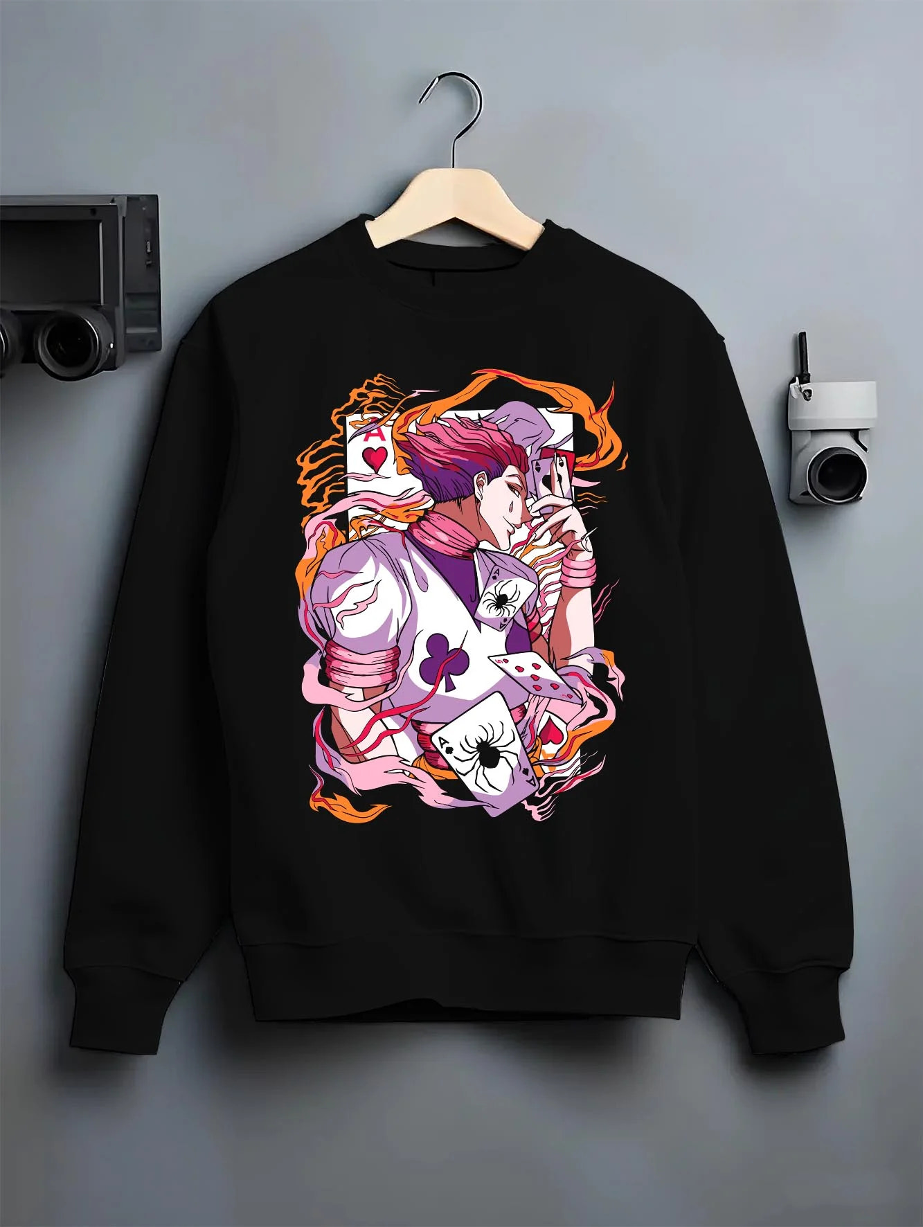 Black crewneck sweatshirt on hanger with Hunter x Hunter Hoodie Hisoka Joker Playing Card Jumper graphic premium wear.