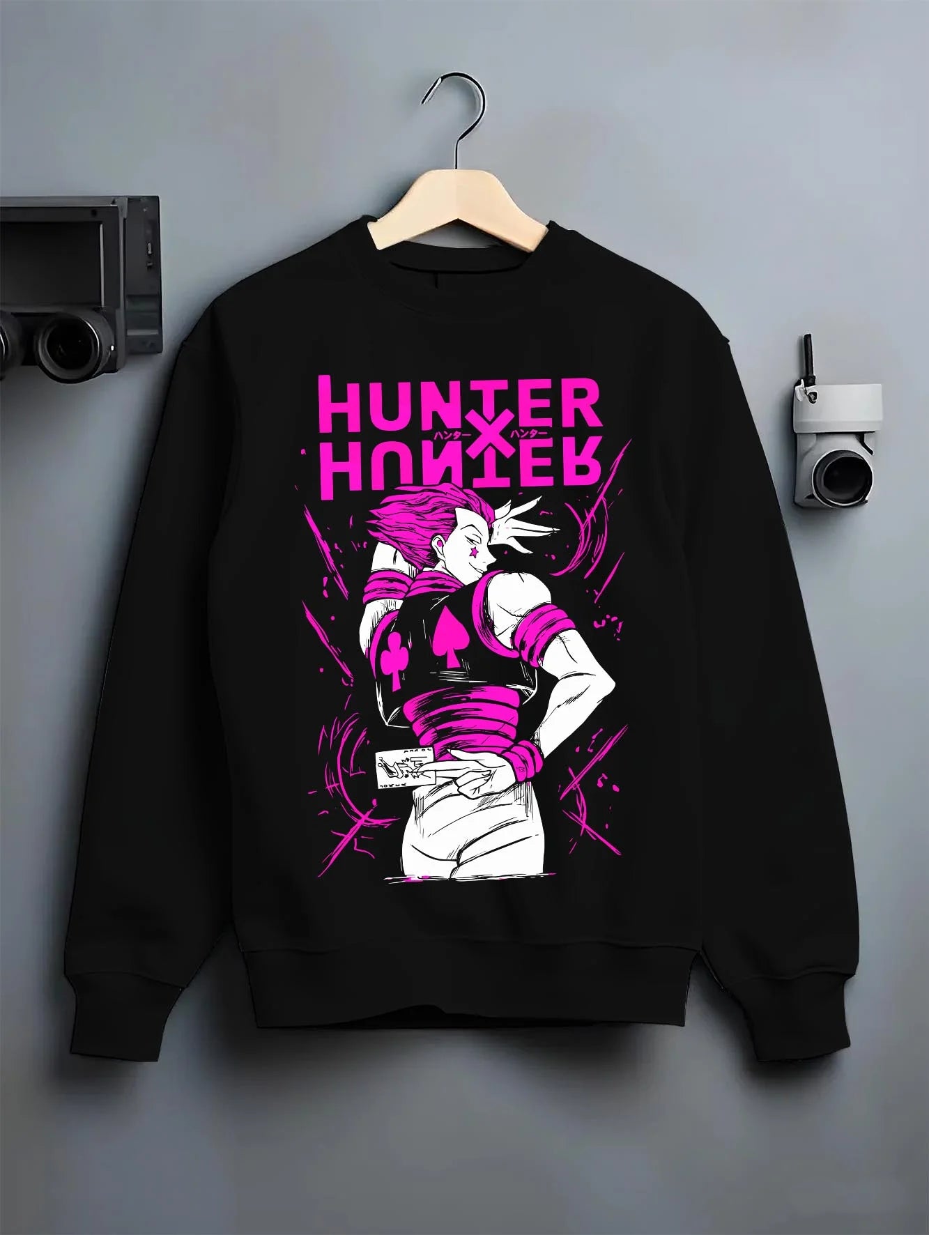 Black crewneck sweatshirt on hanger with Hunter x Hunter Hoodie Hisoka Menacing Stance Jumper graphic bold anime graphic.