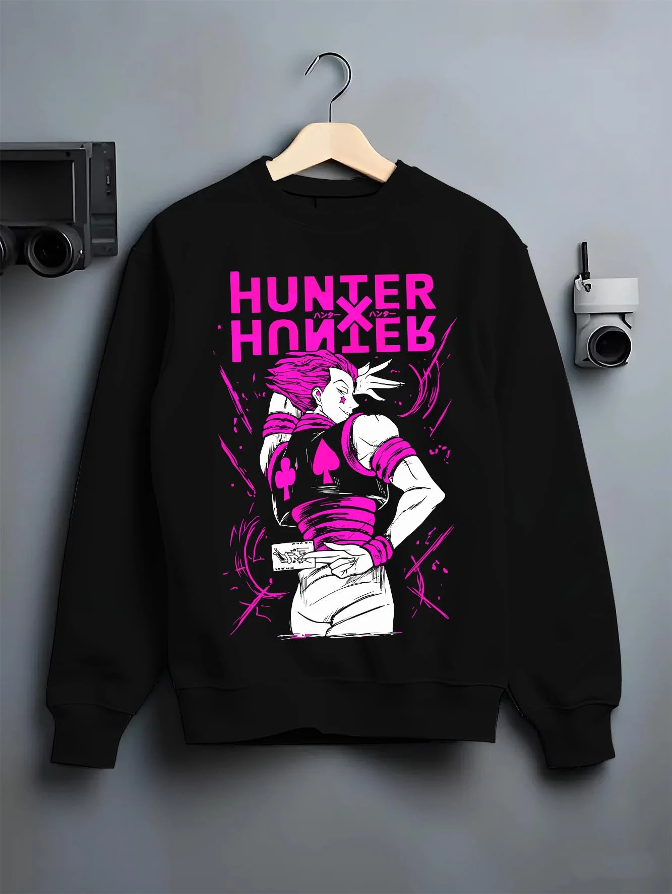Black crewneck sweatshirt on hanger with Hunter x Hunter Hoodie Hisoka Menacing Stance Jumper graphic bold anime graphic.