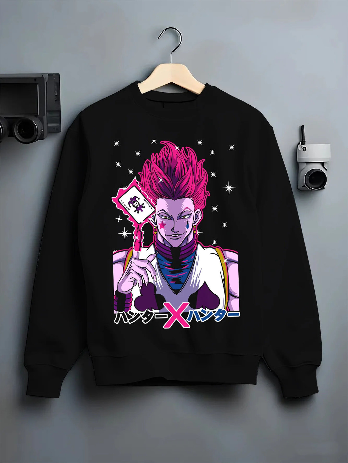 Black crewneck sweatshirt on hanger showing Hisoka Morow from Hunter x Hunter: playing-card portrait