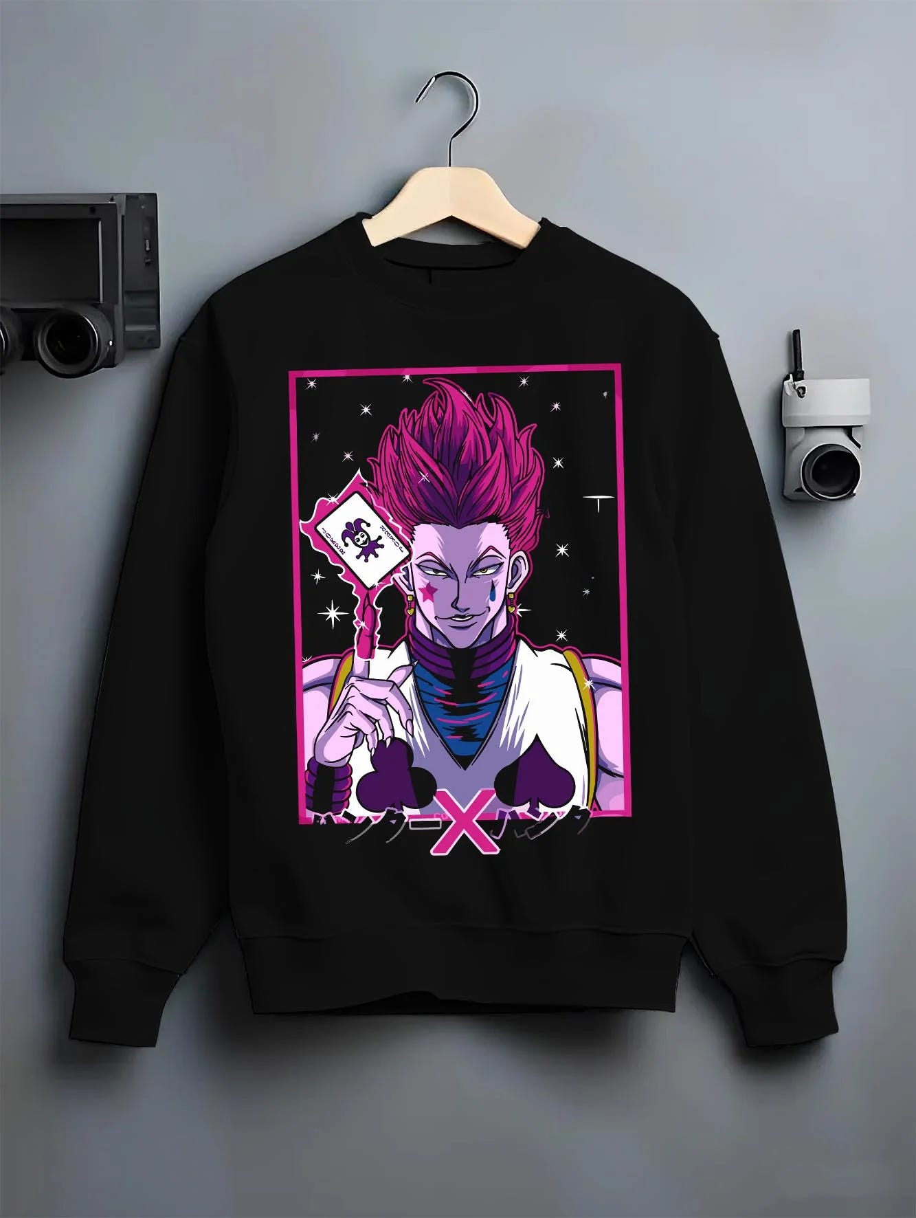 Black crewneck sweatshirt on hanger with Hunter x Hunter Hoodie Hisoka Phantom Troupe Jumper graphic Hisoka anime design.
