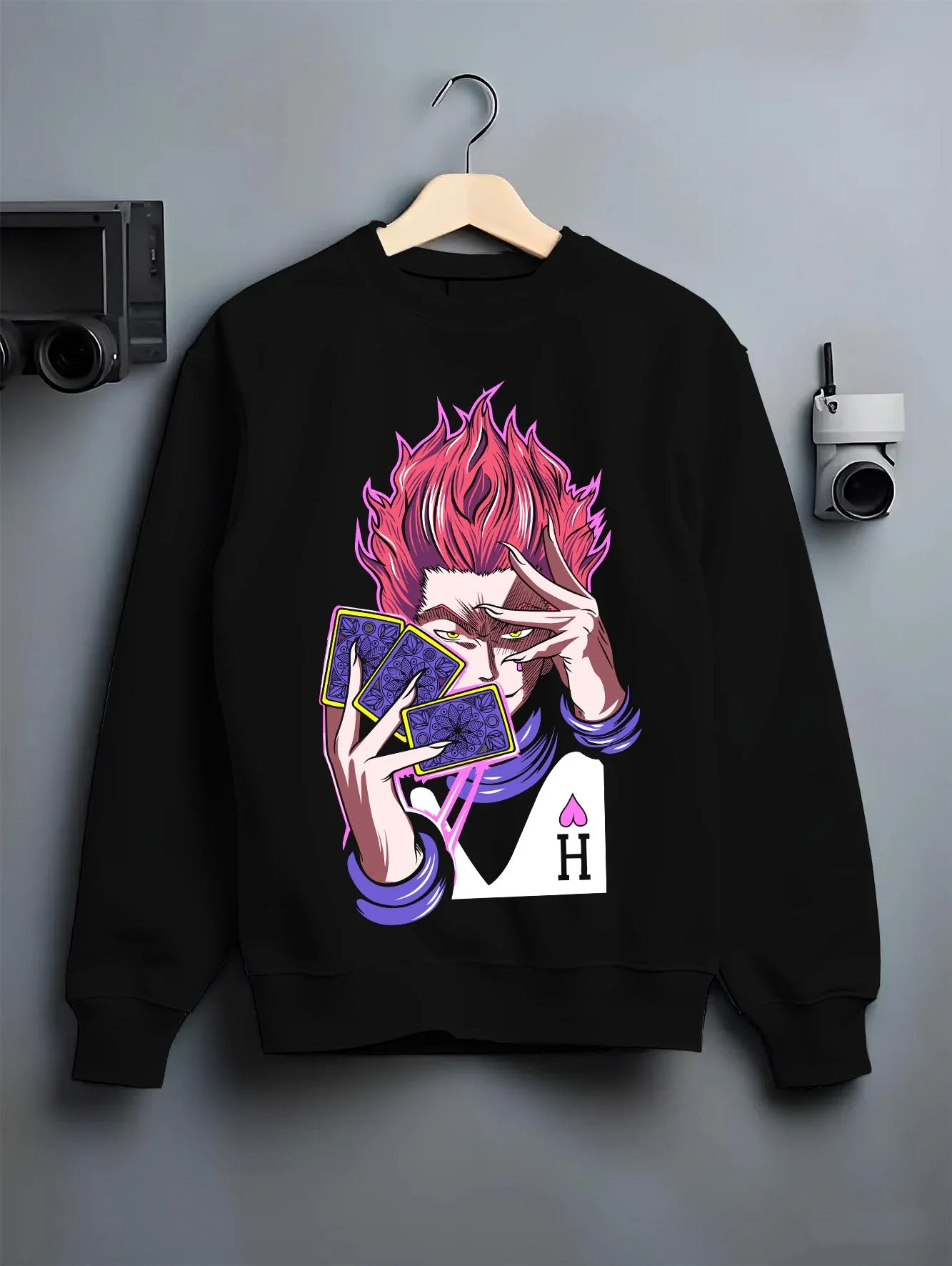 Black crewneck sweatshirt on hanger with Hunter x Hunter Hoodie Hisoka Twisted Smile Jumper graphic bold anime graphic.