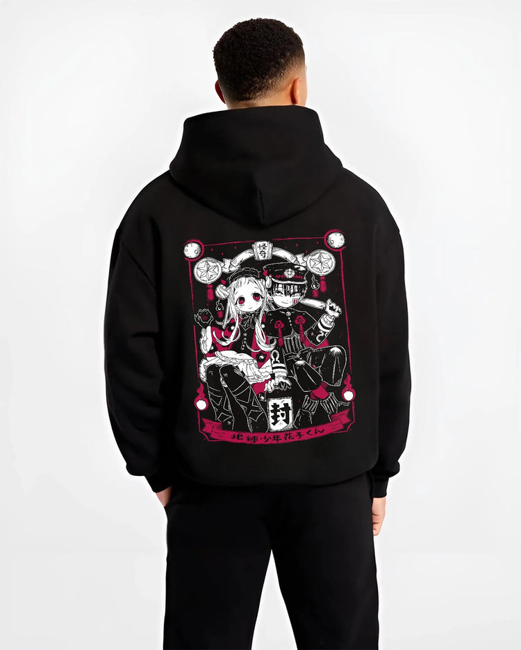 Black hoodie worn by male model, back view, showing Toilet-Bound Hanako-kun artwork of Hanako-kun and Nene Yashiro anime poster inspired design.