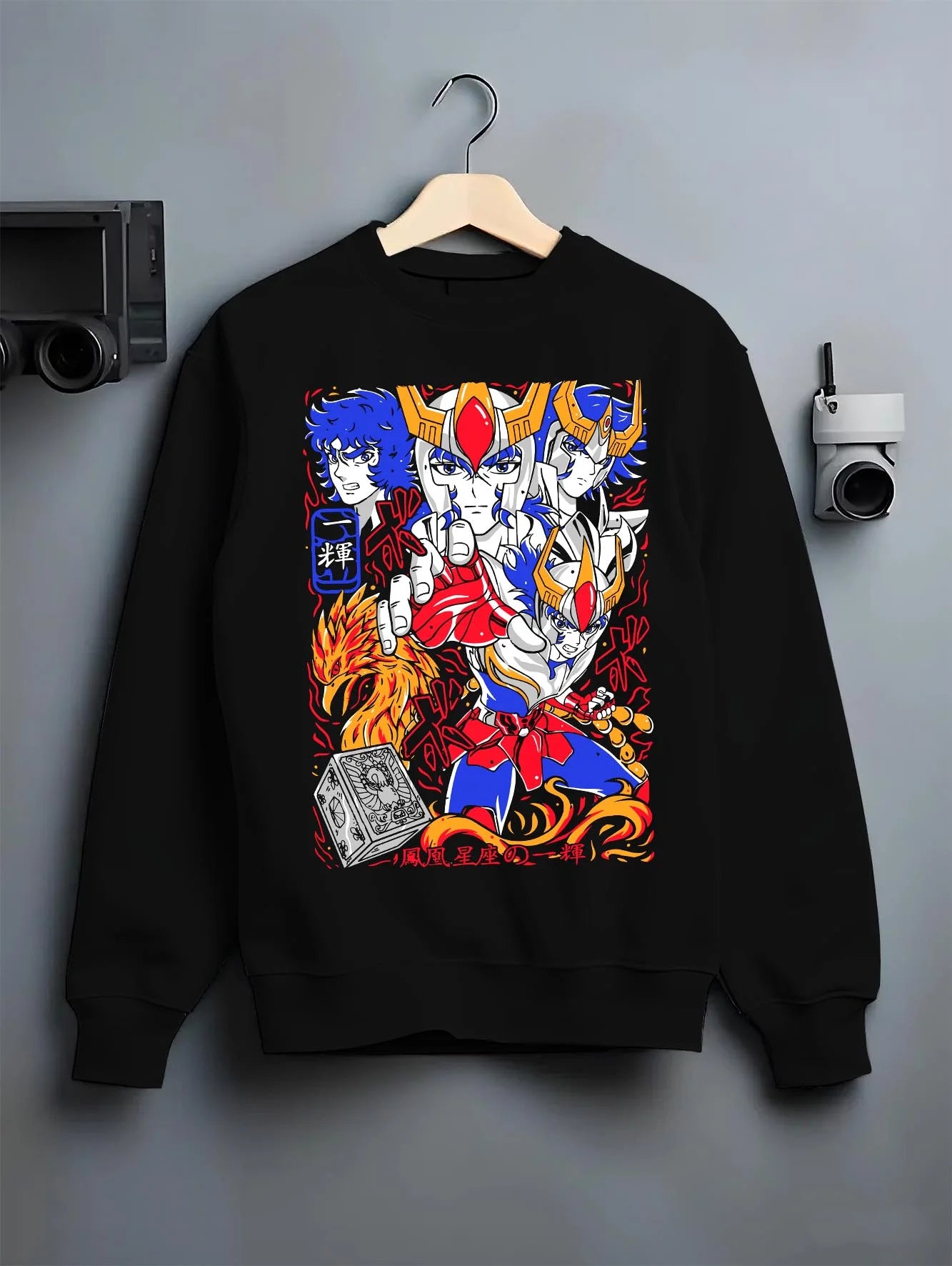 Black crewneck sweatshirt on hanger with Saint Seiya Hoodie Ikki Phoenix Bronze Saint Jumper graphic bold anime graphic.