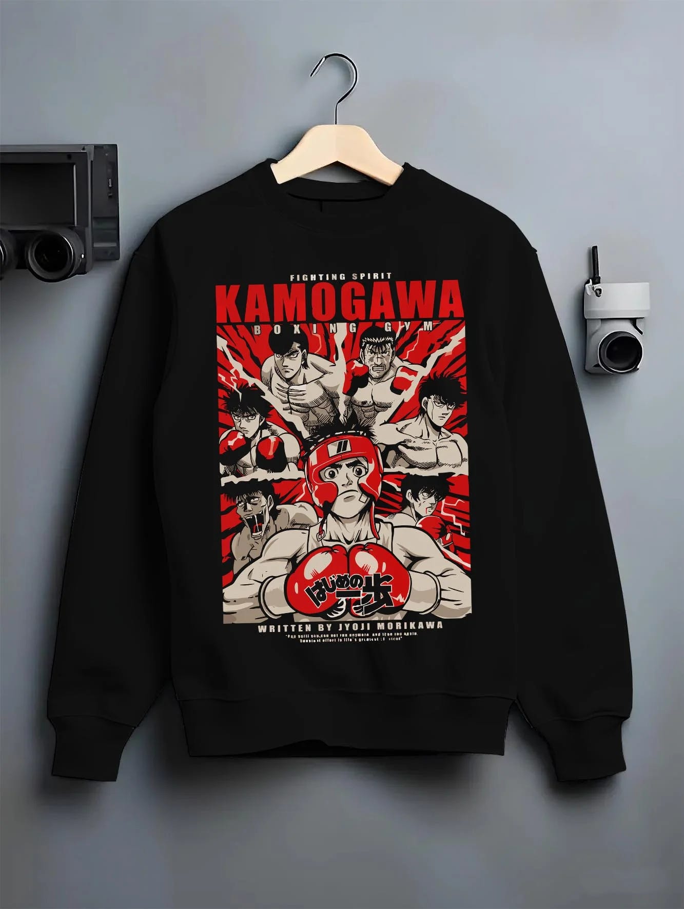 Black crewneck sweatshirt on hanger with Hajime no Ippo Hoodie Kamogawa Gym Boxing Jumper graphic streetwear graphic.