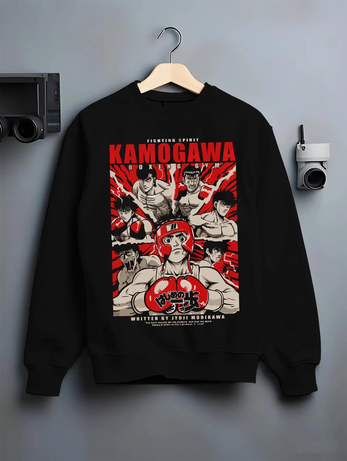 Black crewneck sweatshirt on hanger with Hajime no Ippo Hoodie Kamogawa Gym Boxing Jumper graphic streetwear graphic.