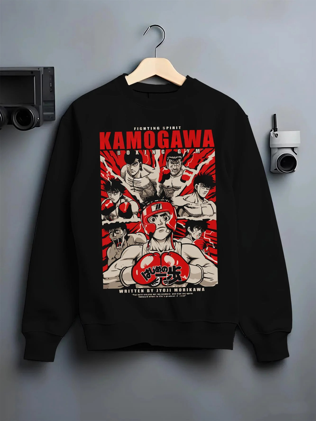 Black crewneck sweatshirt on hanger with Hajime no Ippo Hoodie Kamogawa Gym Boxing Jumper graphic streetwear graphic.