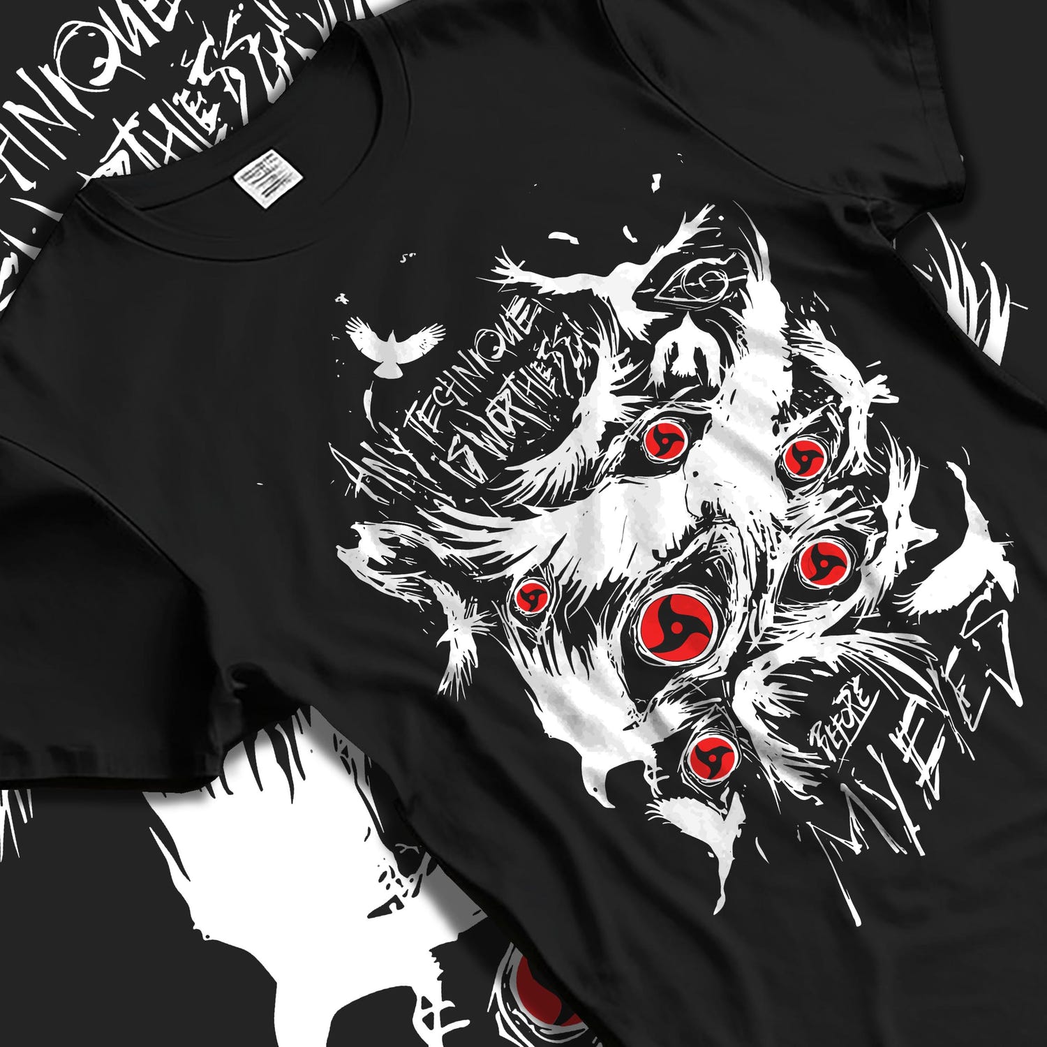 Black T-shirt laid flat with natural fabric folds, featuring Naruto Sharingan shonen battle character design with intense red eyes and dark manga panel style.