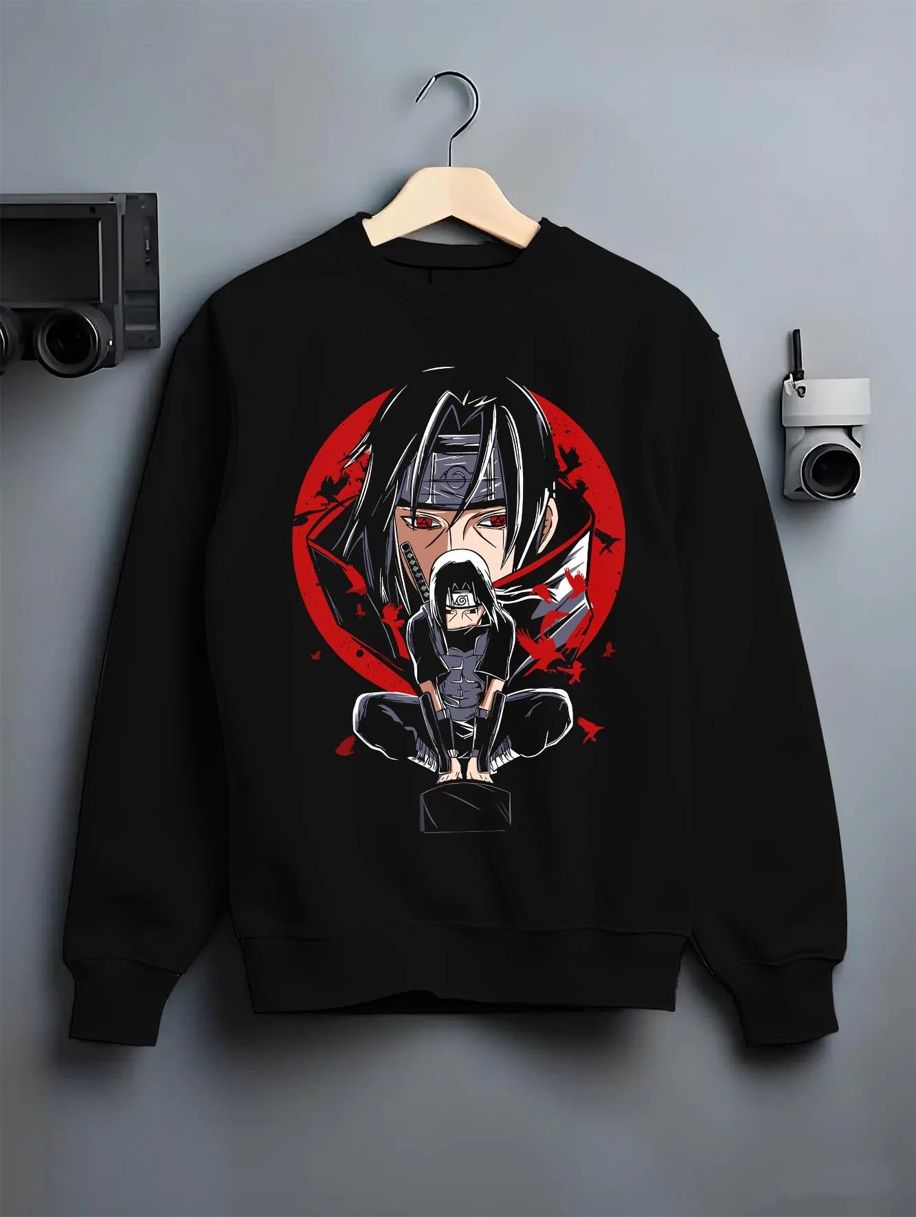 Black crewneck sweatshirt on hanger with Naruto Hoodie Itachi Uchiha Mangekyo Clan Jumper graphic streetwear graphic.