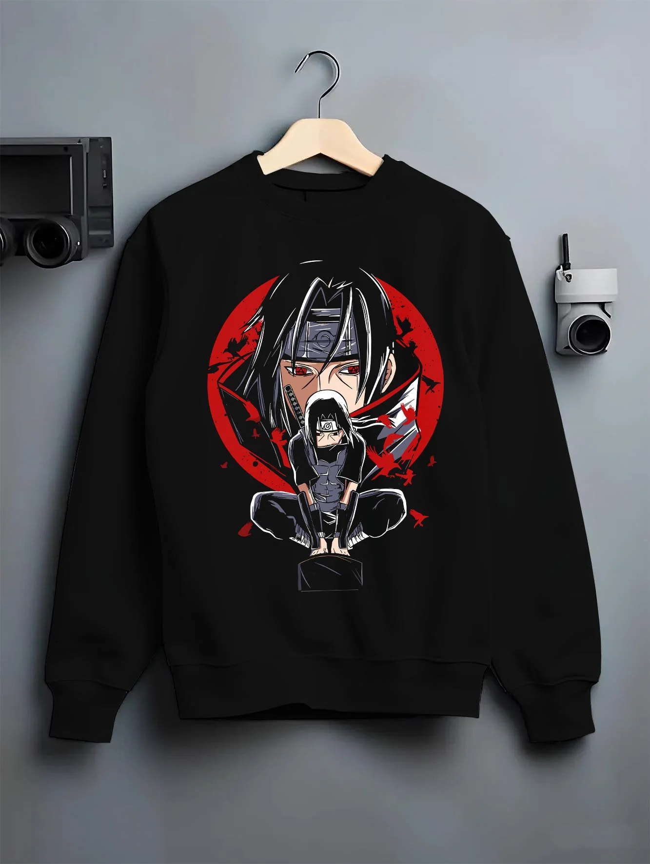 Black crewneck sweatshirt on hanger with Naruto Hoodie Itachi Uchiha Mangekyo Clan Jumper graphic streetwear graphic.