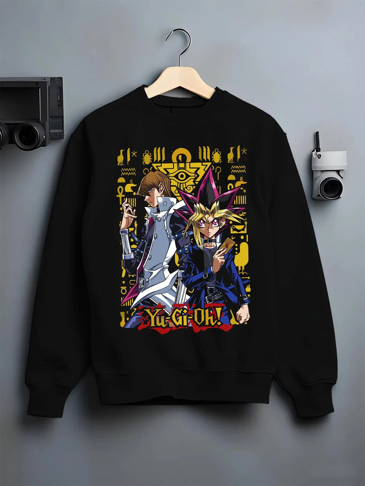 Black crewneck sweatshirt on hanger featuring Yugi and Kaiba duel rivals artwork.