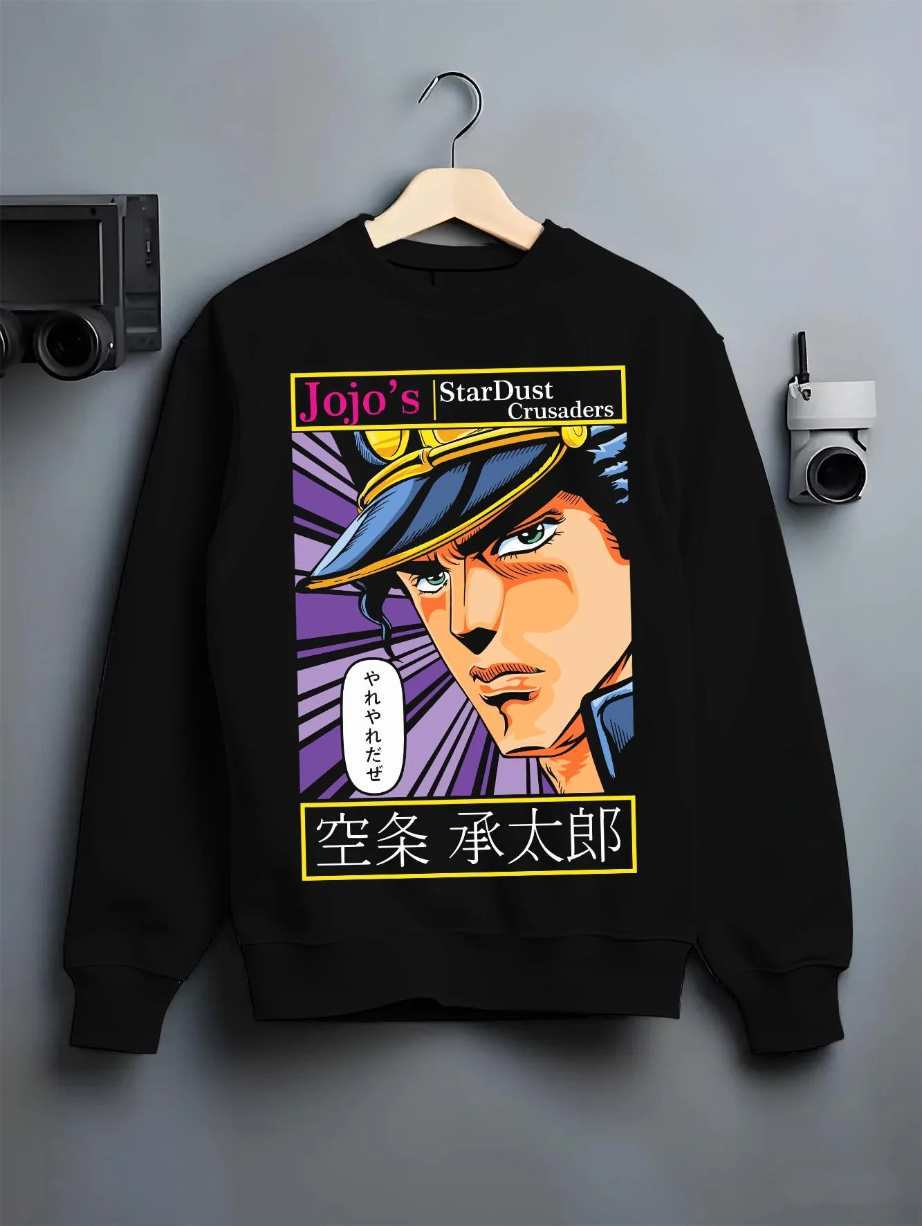 Black crewneck sweatshirt on hanger with Jotaro Kujo Hoodie JoJo’s Bizarre Adventure Stardust Arc graphic premium wear.