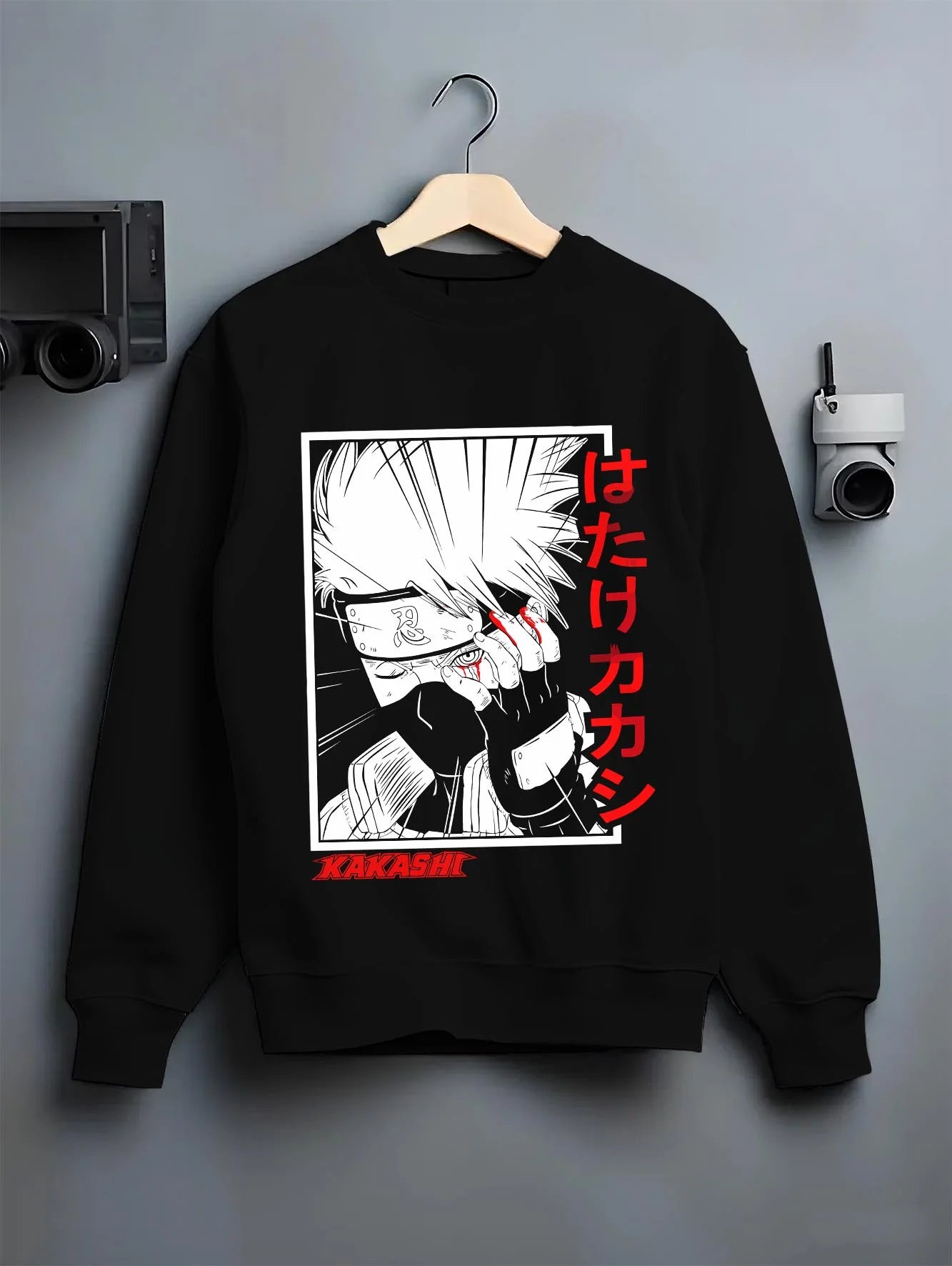 Black crewneck sweatshirt on hanger with Kakashi Hatake Hoodie Naruto Copy Ninja Hidden Leaf graphic streetwear graphic.