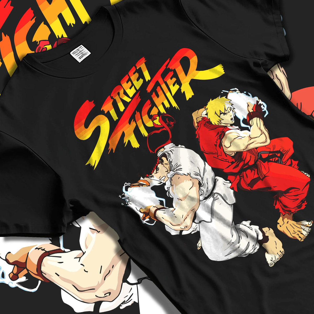 Black T-shirt laid flat with natural folds featuring Ken Masters and Ryu rival battle artwork.