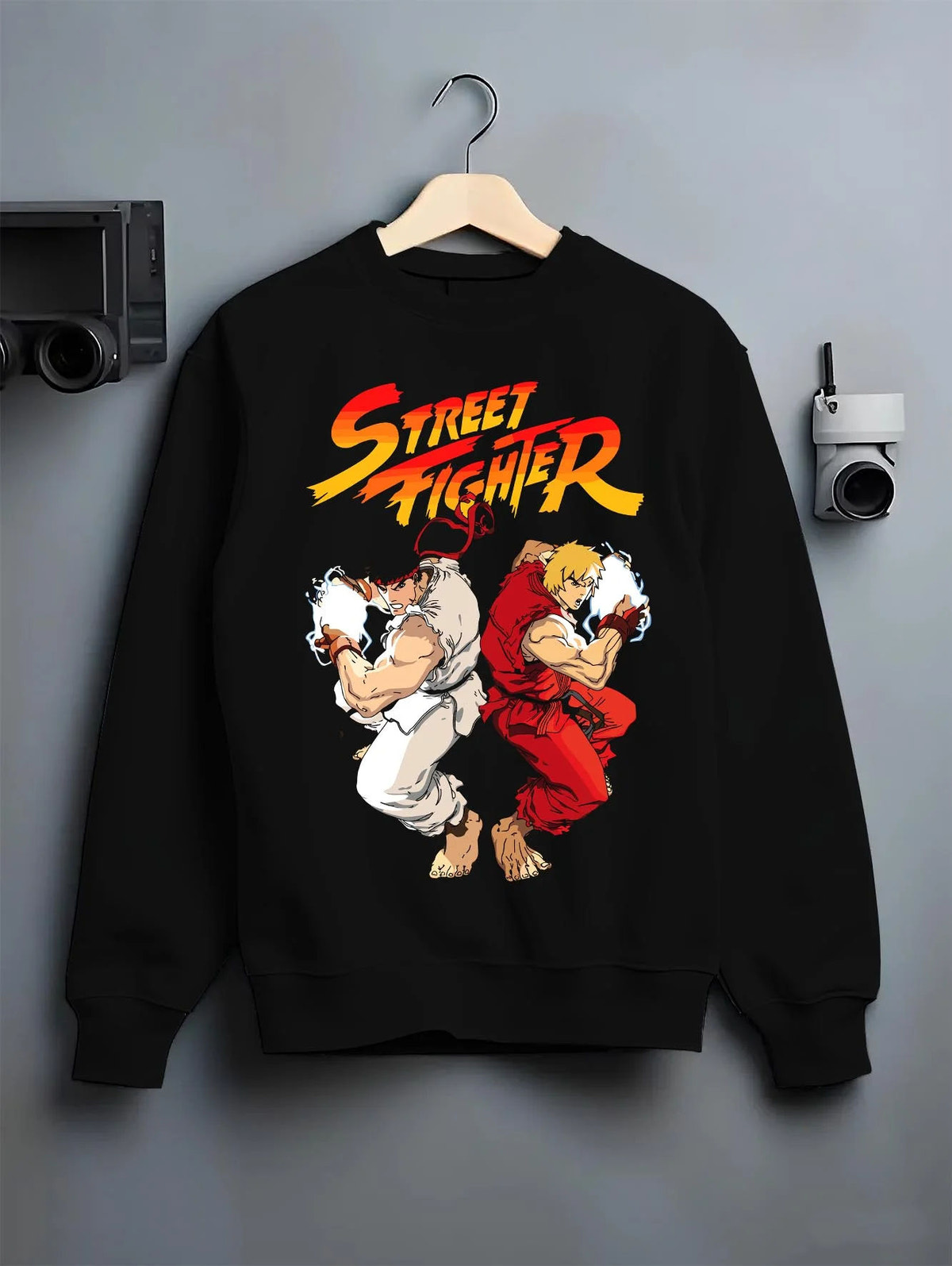 Black crewneck sweatshirt on hanger featuring Ken Masters and Ryu rival battle artwork.