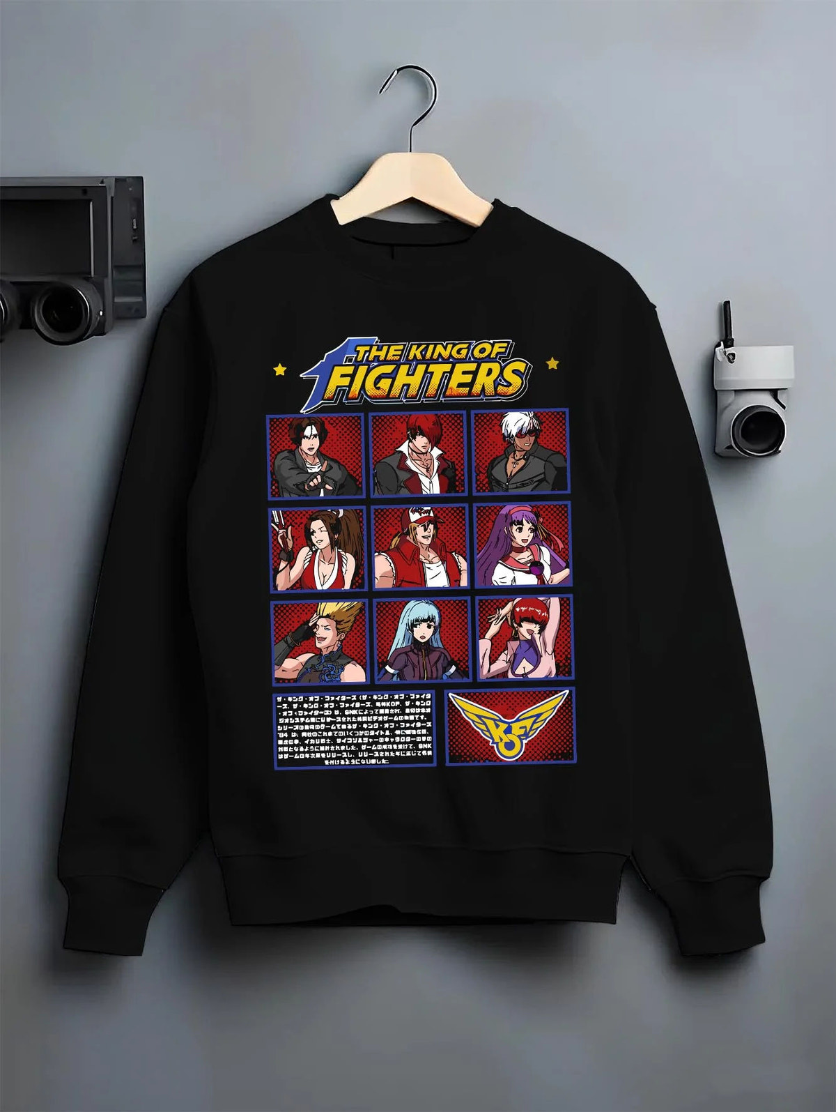 Black crewneck sweatshirt on hanger featuring King of Fighters character roster artwork.