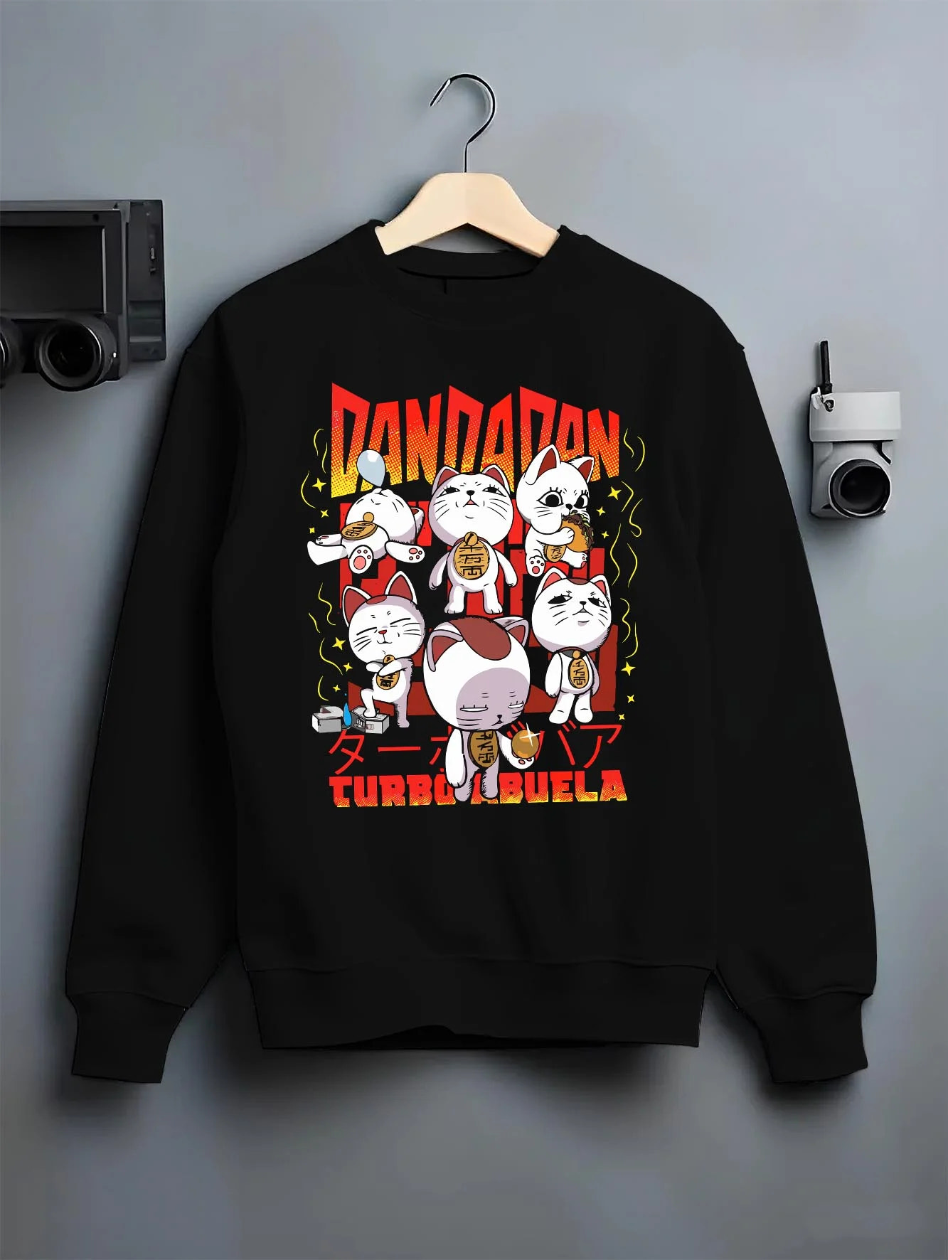 Black crewneck sweatshirt on hanger with Dandadan Turbo Granny Hoodie Cat Spirits Anime Jumper graphic bold anime graphic.