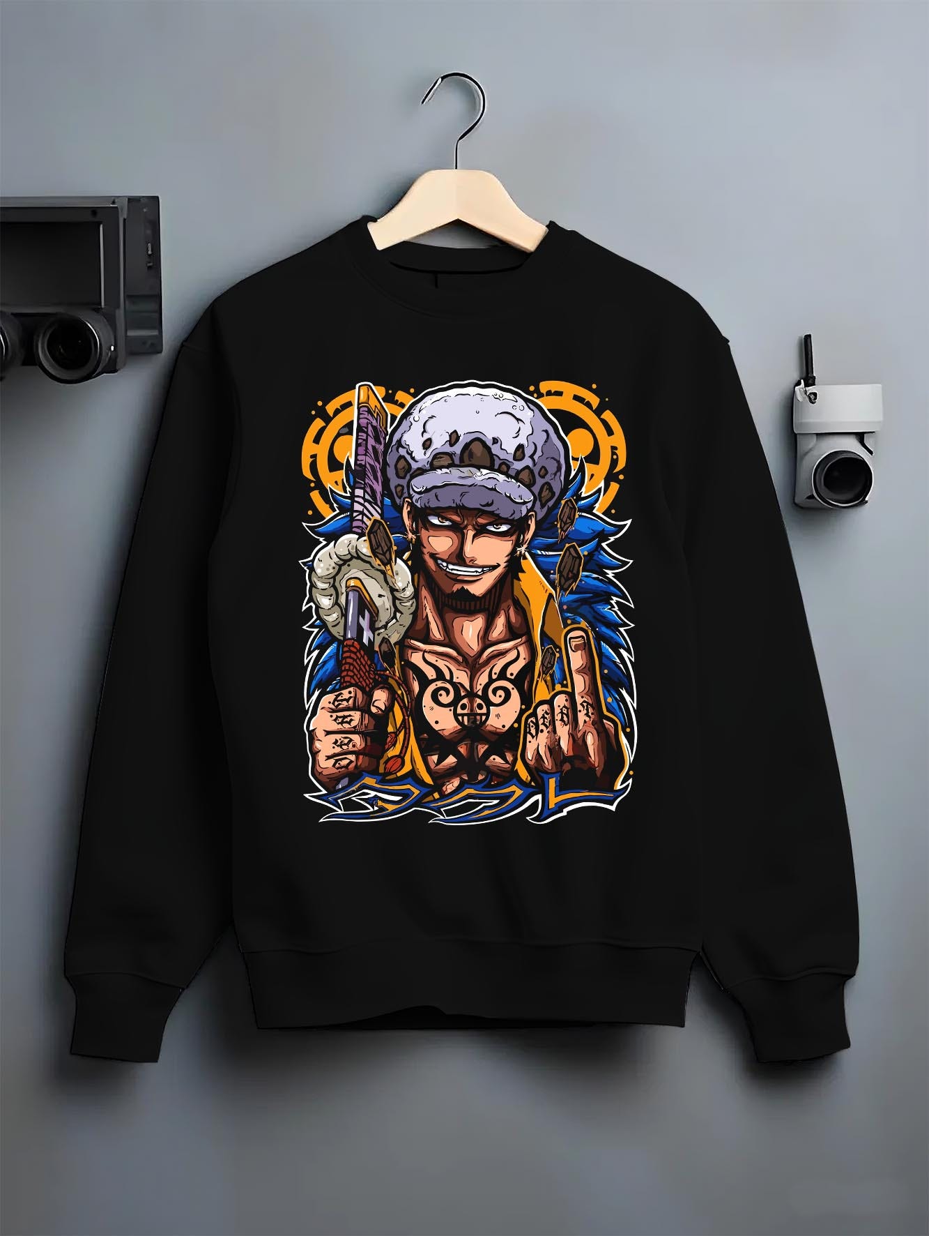 Black crewneck sweatshirt on a hanger against a grey wall, featuring One Piece Trafalgar Law modern streetwear back graphic.