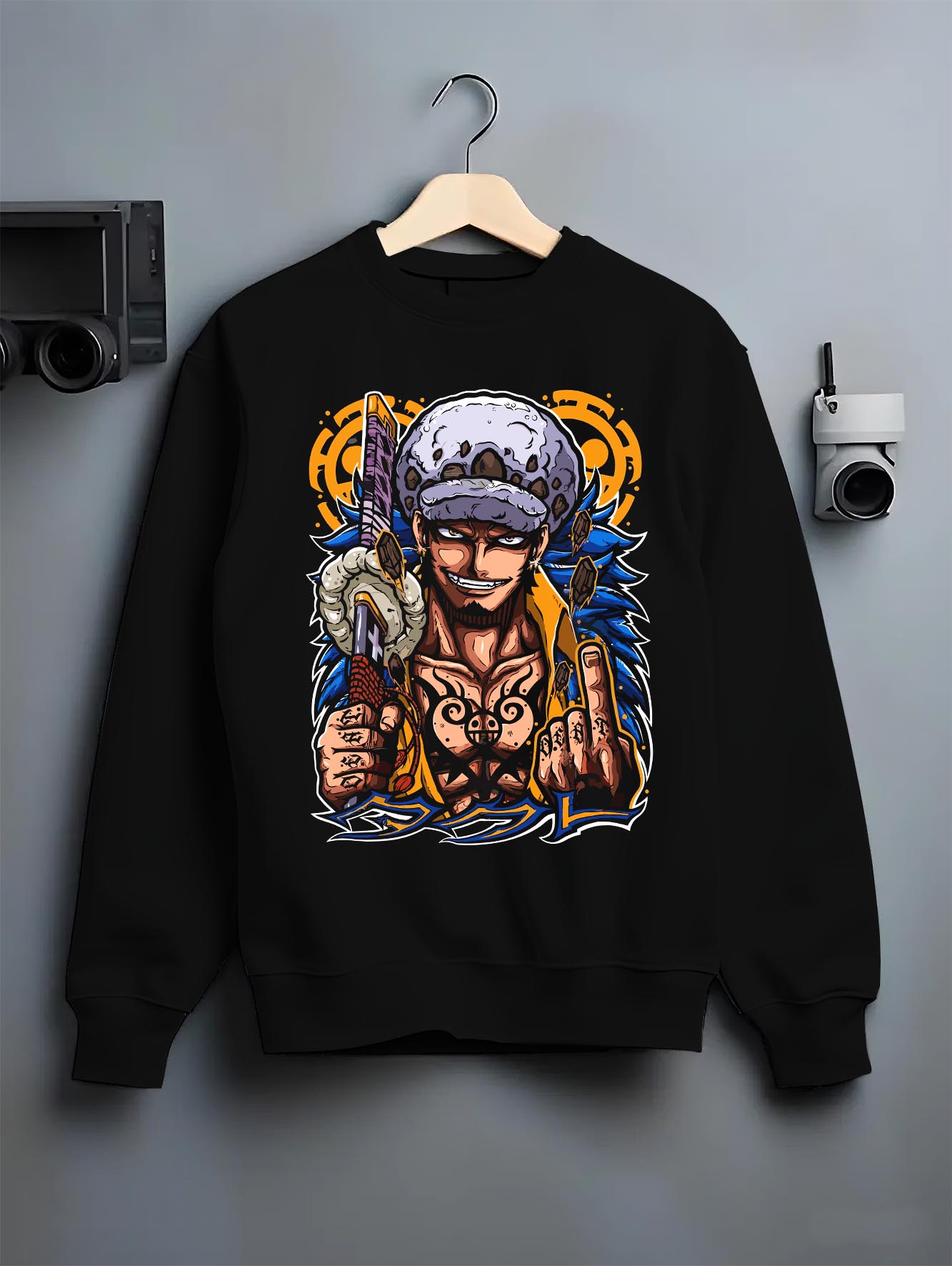Black crewneck sweatshirt on a hanger against a grey wall, featuring One Piece Trafalgar Law modern streetwear back graphic.