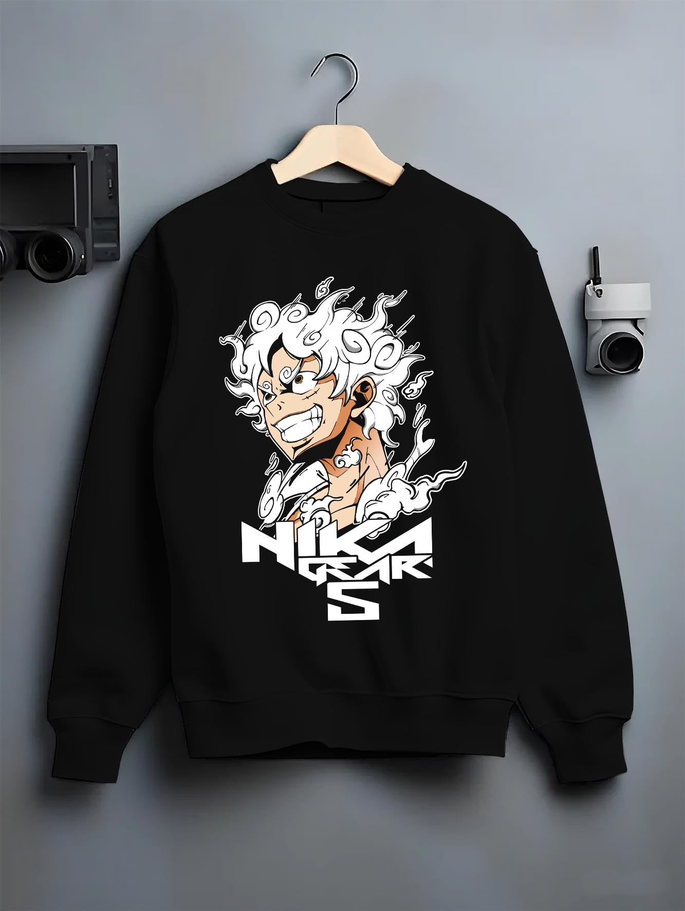Black crewneck sweatshirt on a hanger against a grey wall, featuring One Piece Luffy Gear 5 modern streetwear artwork.