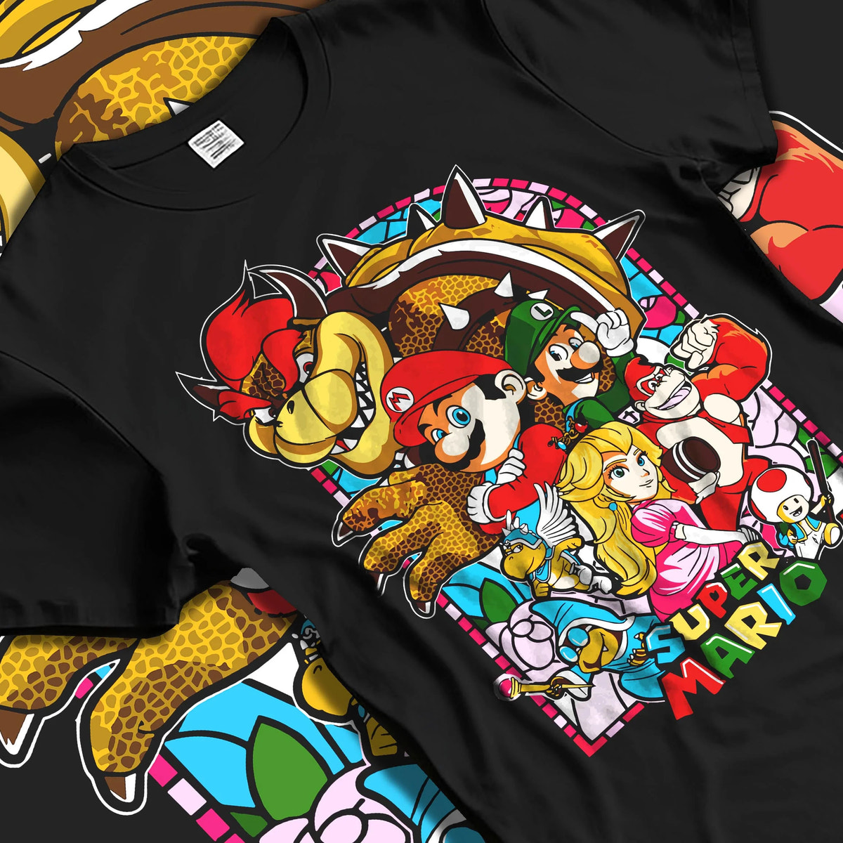 Black T-shirt laid flat with natural folds featuring Mario and the Mushroom Kingdom cast artwork.