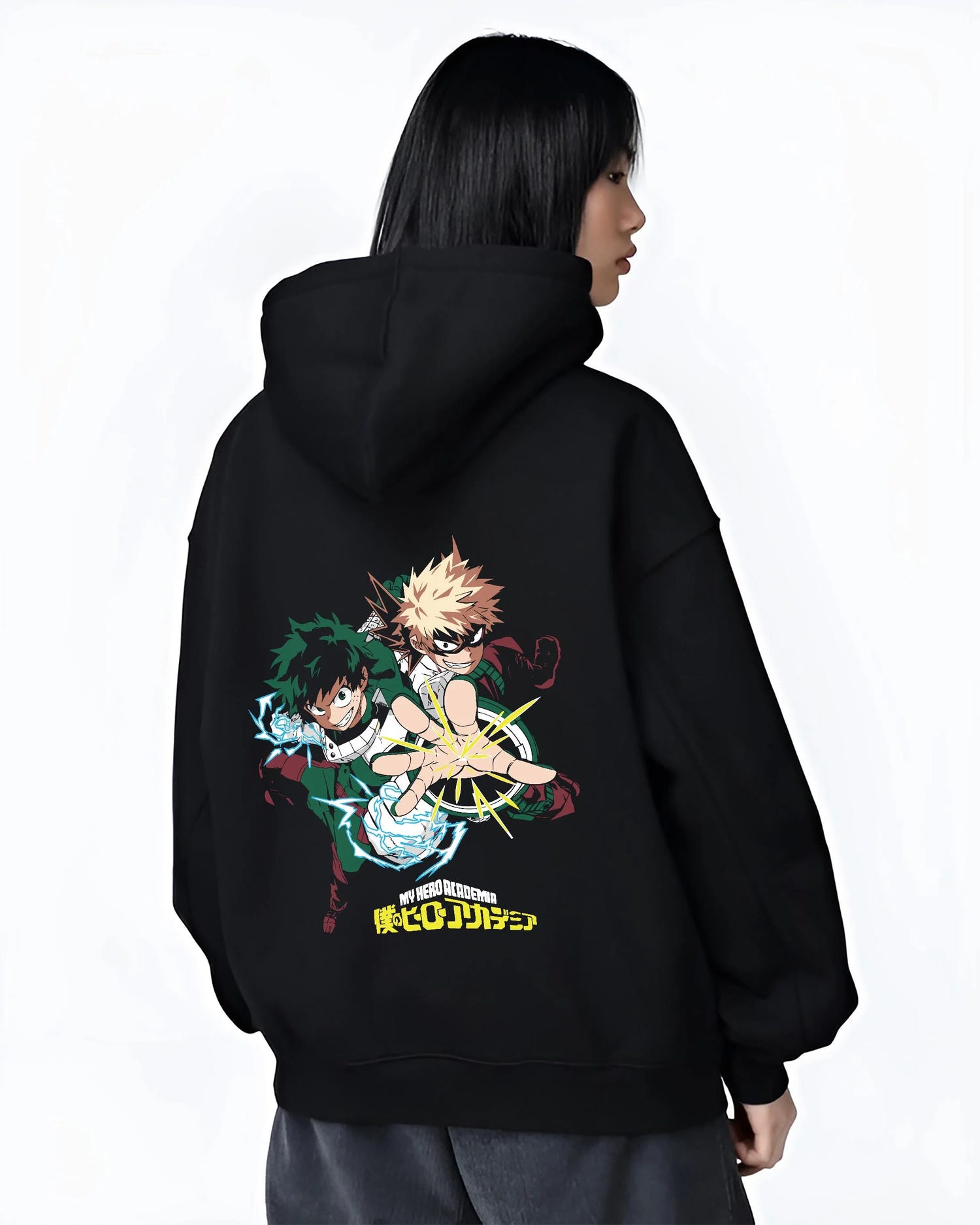 Black hoodie worn by female model, back view with Deku Bakugo Hoodie My Hero Academia Training Arc graphic bold anime graphic.