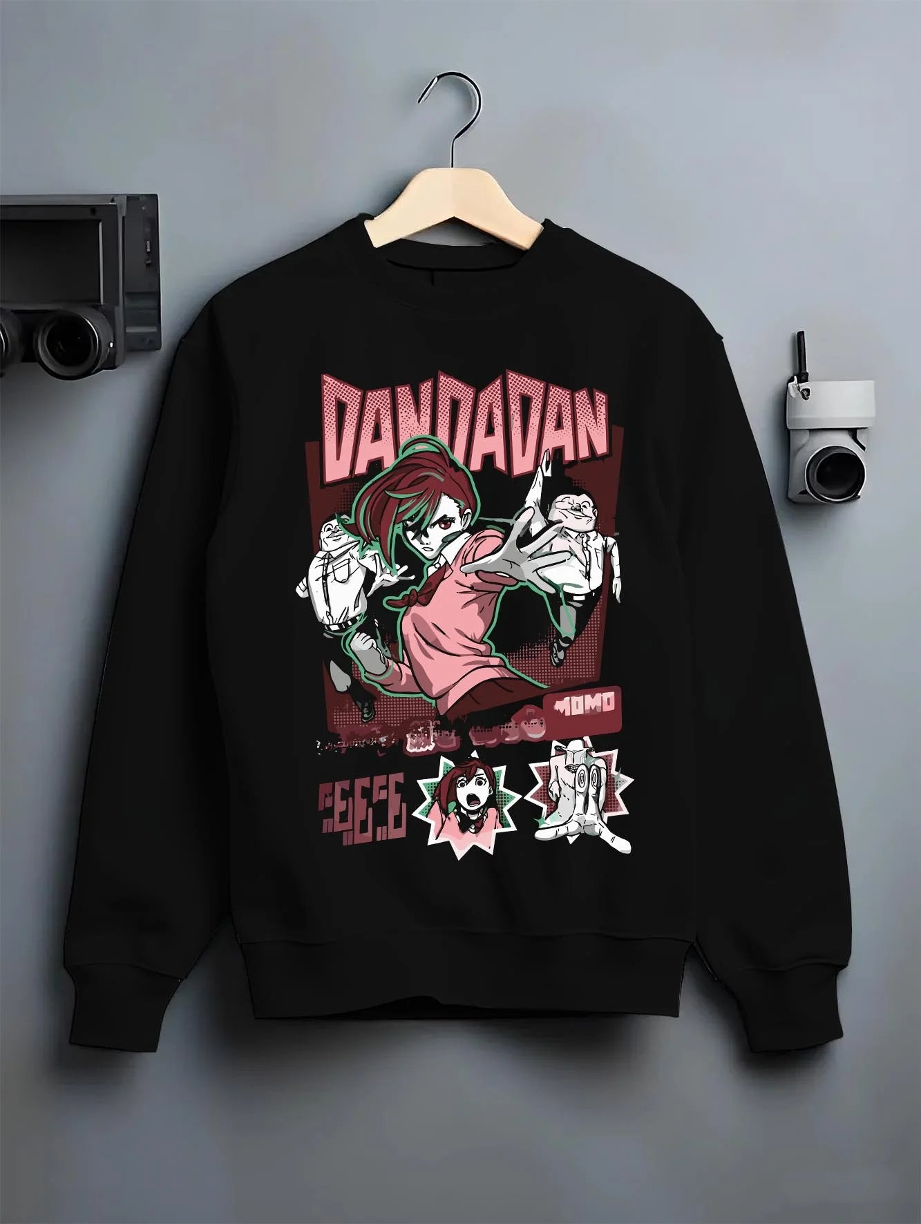 Black crewneck sweatshirt on hanger with Okarun Hoodie Dandadan Paranormal Spirit Battle graphic bold anime graphic.