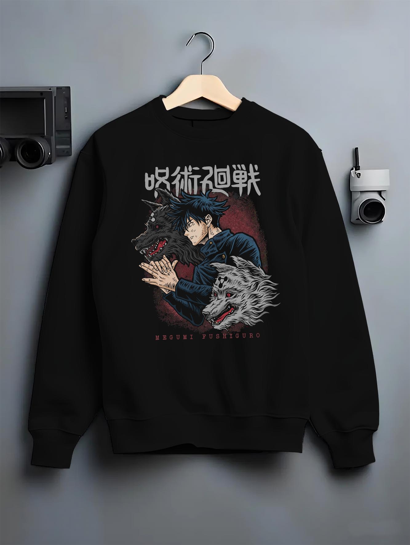 Black crewneck sweatshirt on a hanger against a grey wall, featuring Megumi Fushiguro Divine Dogs retro manga graphic.
