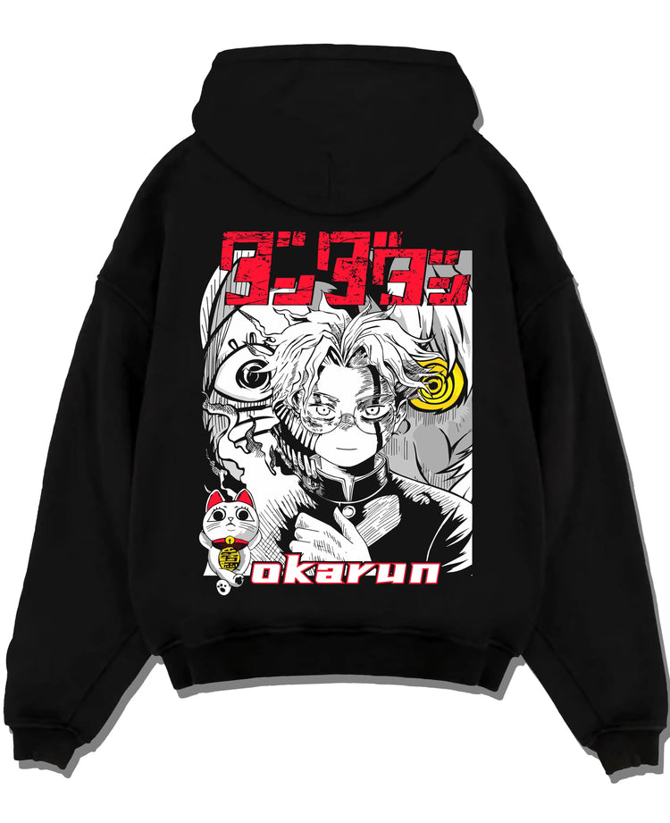 Black pullover hoodie laid flat with Okarun Hoodie Dandadan Paranormal Occult Fighter graphic bold anime graphic.