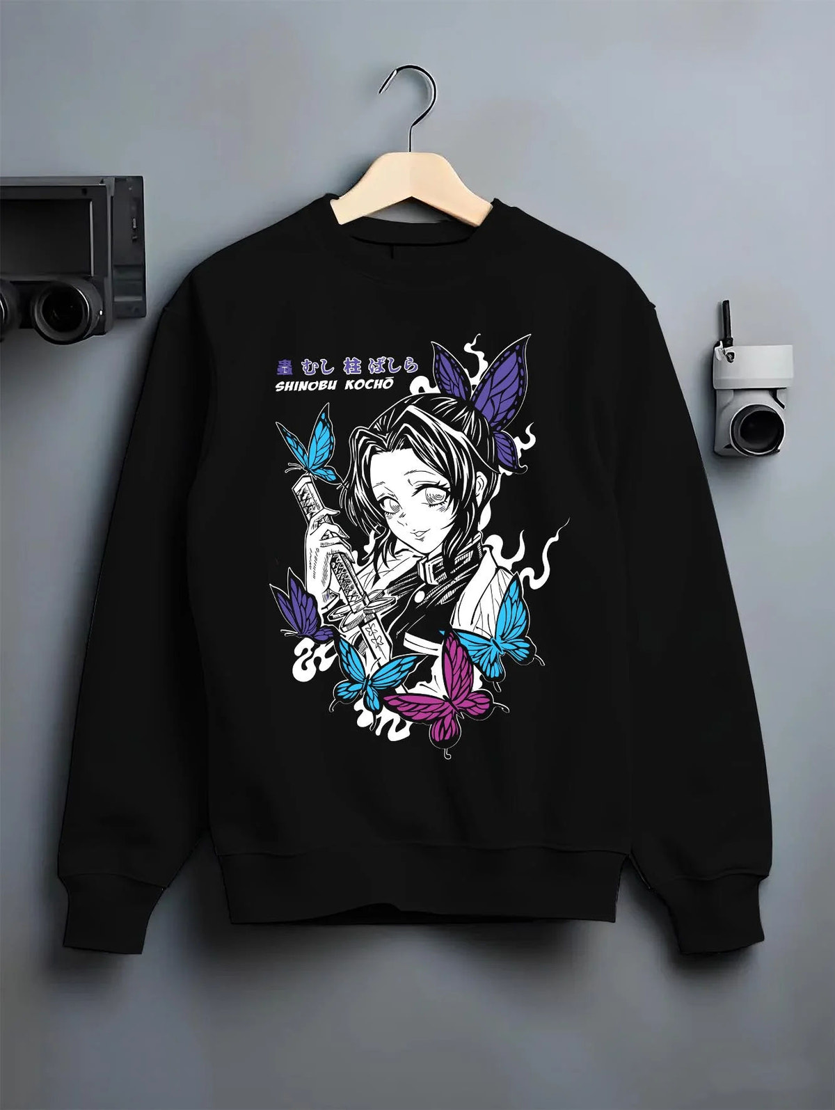 Black crewneck sweatshirt on hanger featuring Shinobu Kocho butterfly poison Demon Slayer artwork.