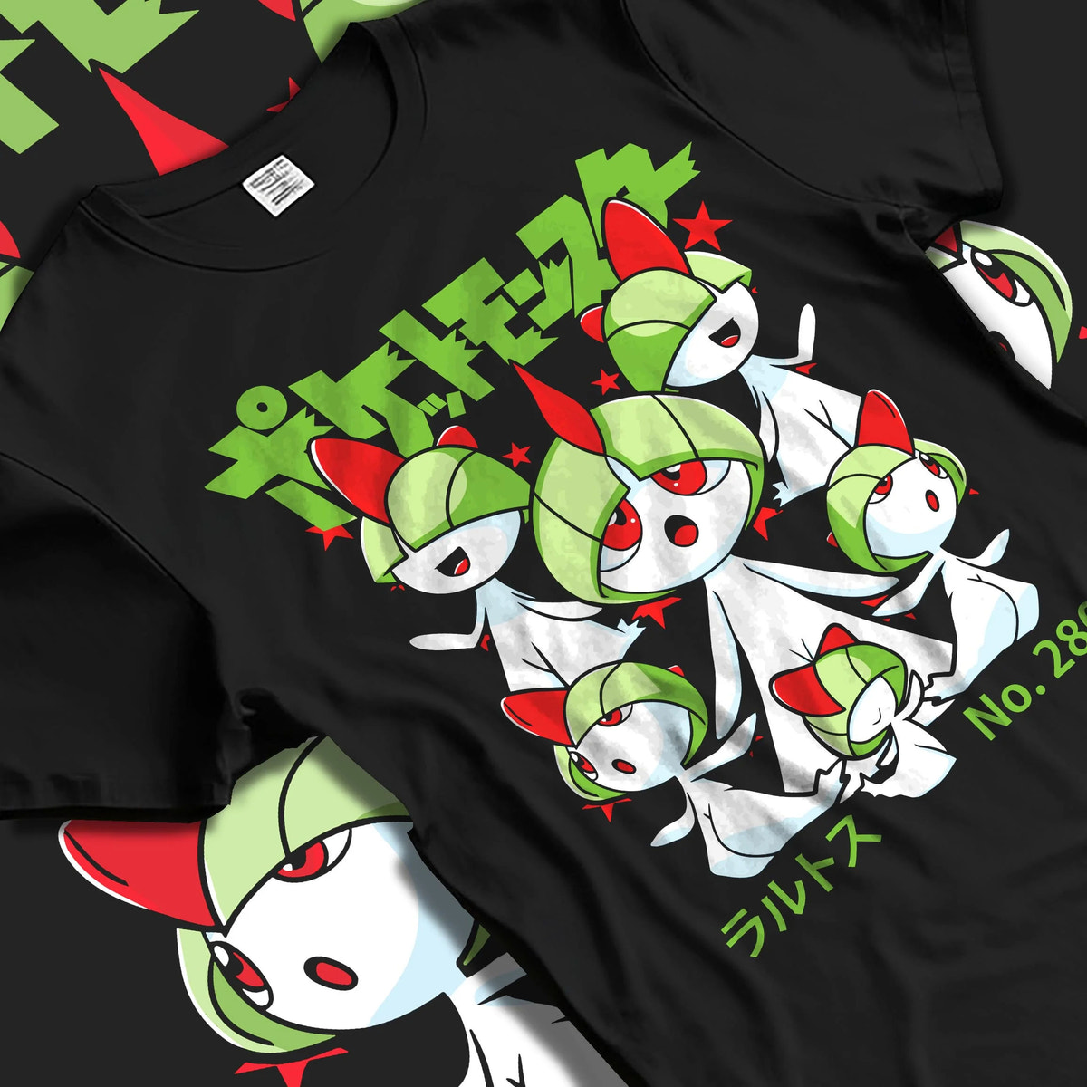 Black T-shirt laid flat with natural folds featuring Ralts psychic fairy evolution family Pokemon artwork.