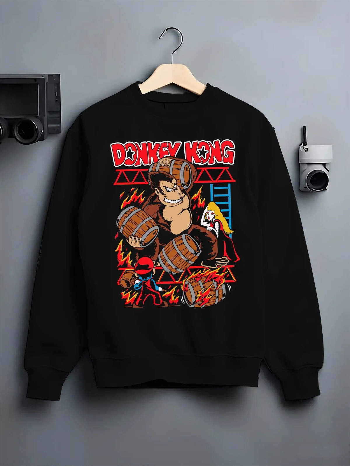 Black crewneck sweatshirt on hanger featuring Donkey Kong barrel throw artwork.