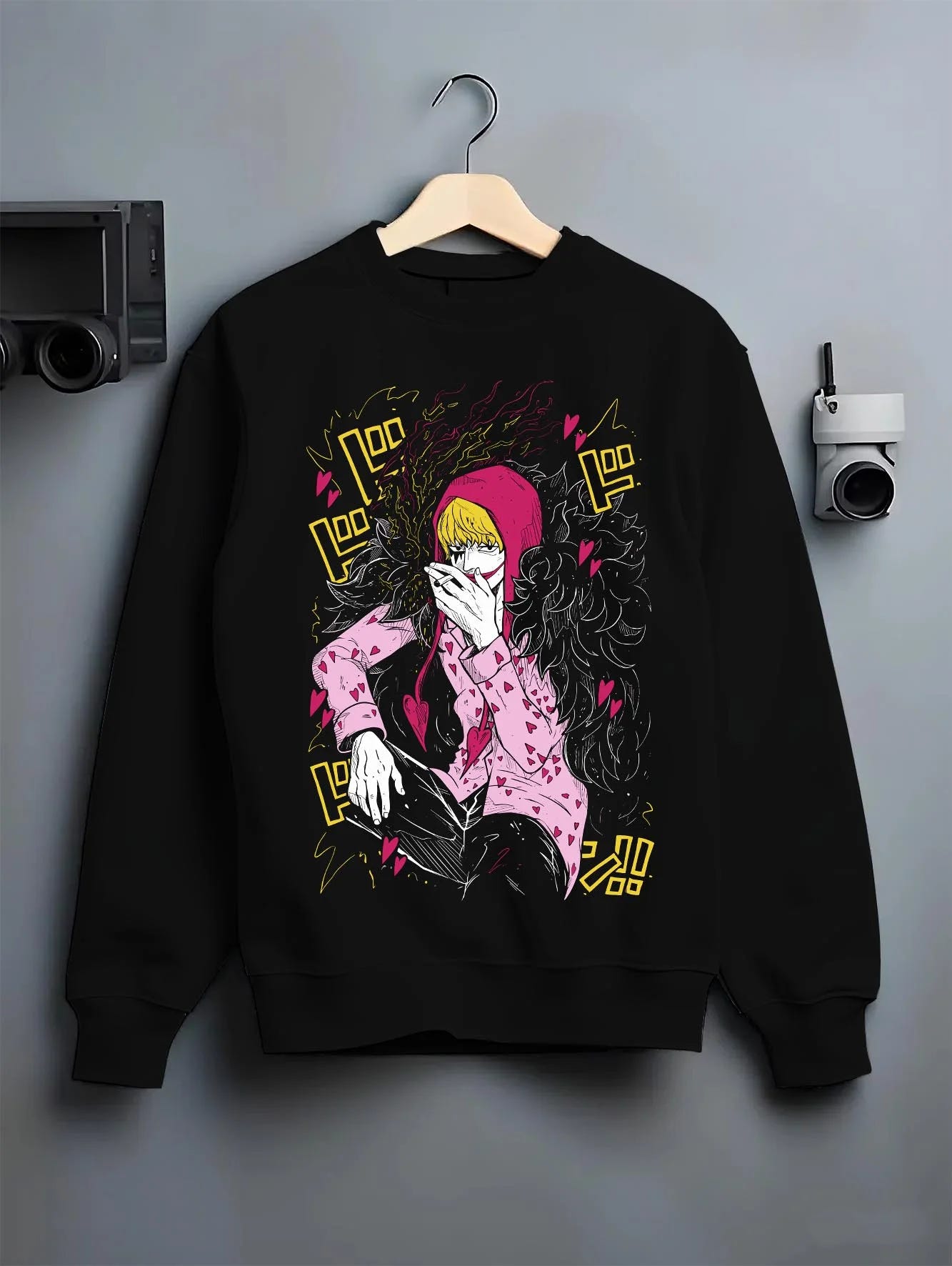 Black crewneck sweatshirt on hanger against grey wall, featuring dark manga panel inspired Corazon design from One Piece.