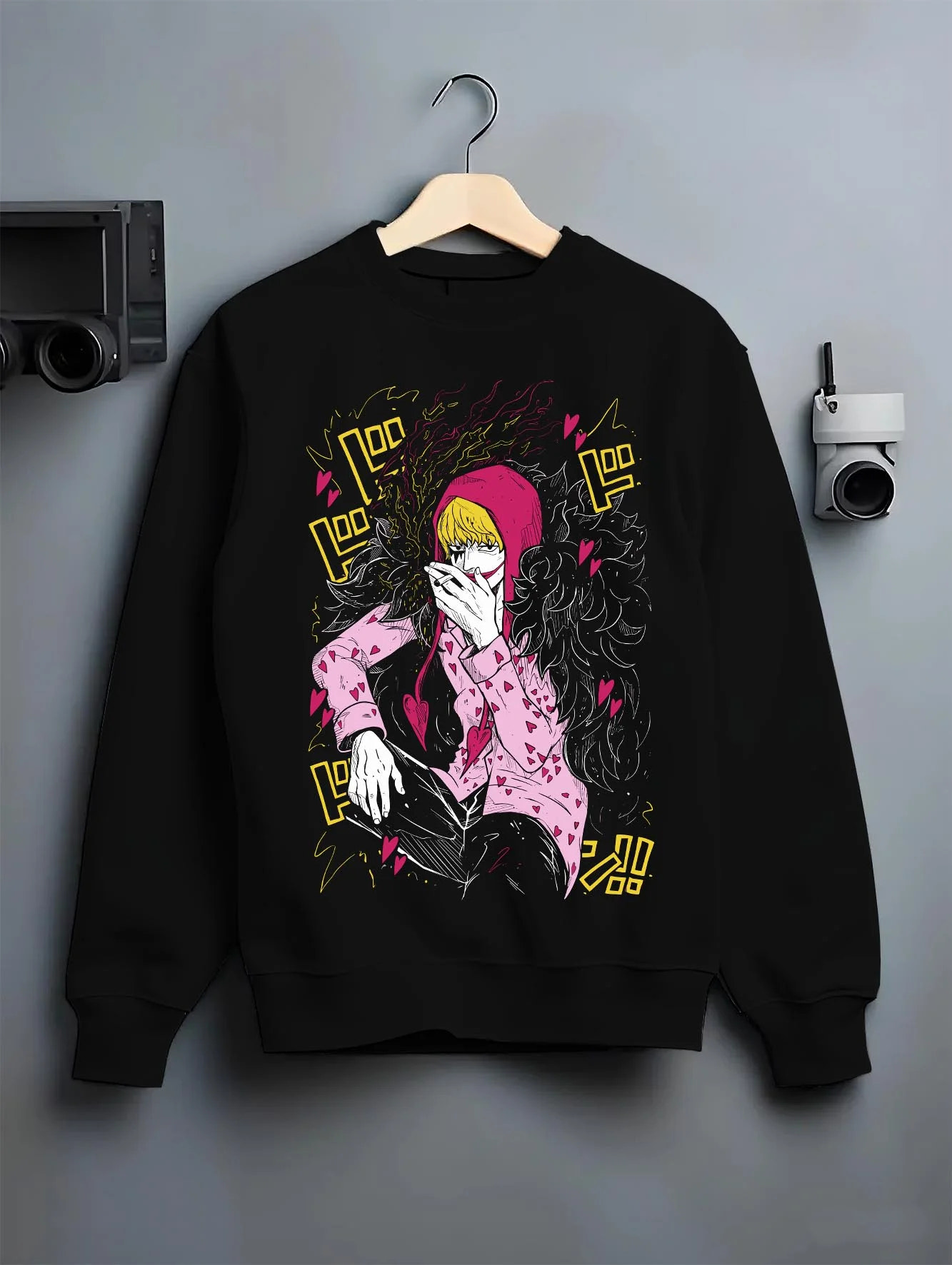 Black crewneck sweatshirt on hanger against grey wall, featuring dark manga panel inspired Corazon design from One Piece.