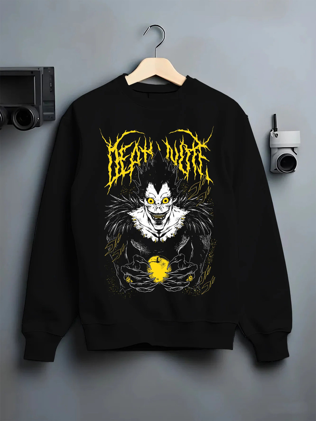 Black crewneck sweatshirt on hanger showing Ryuk from Death Note: Shinigami with apple