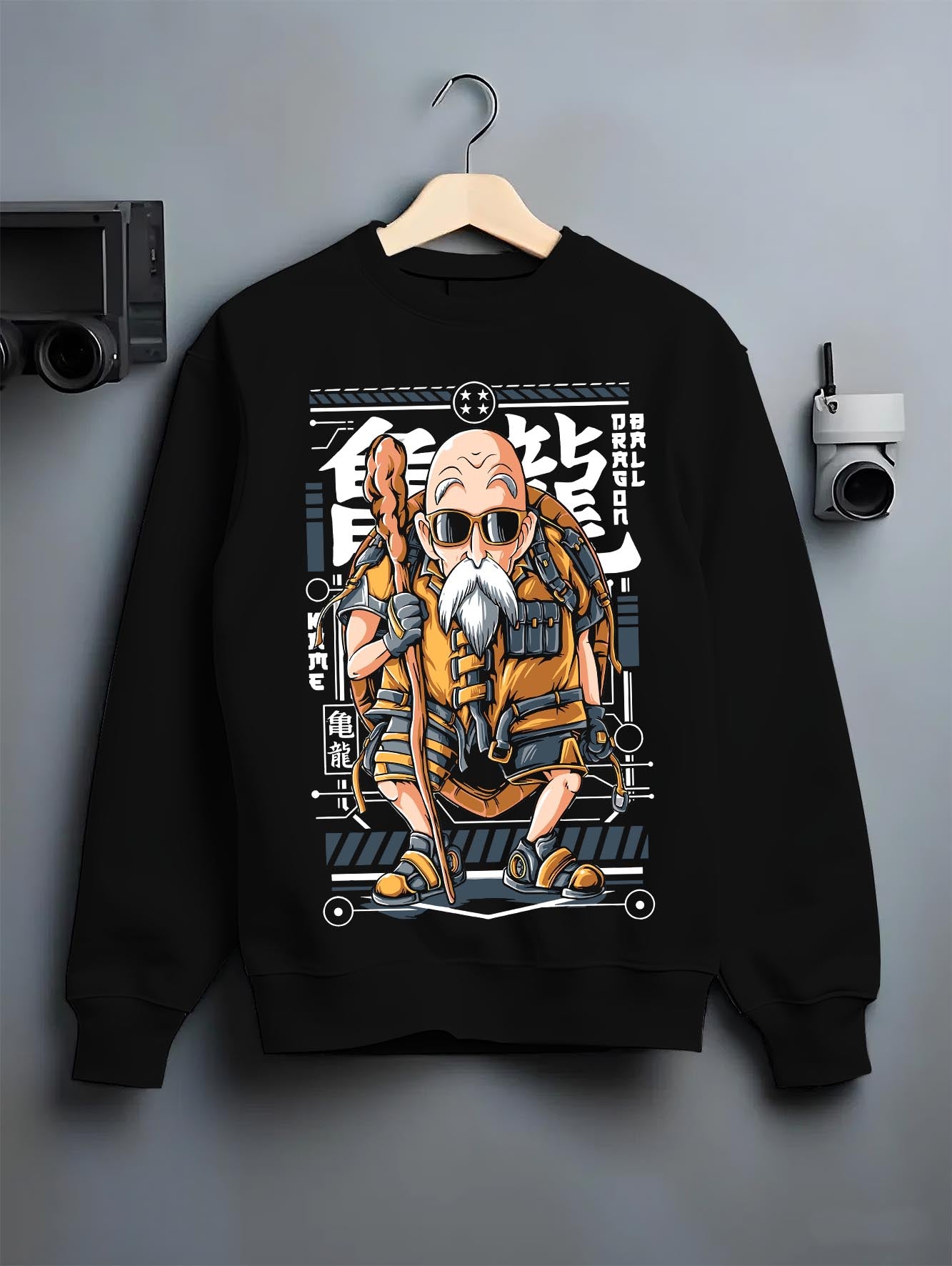Black crewneck sweatshirt on a hanger against a grey wall, featuring Dragon Ball Master Roshi anime poster inspired retro Japanese manga artwork.