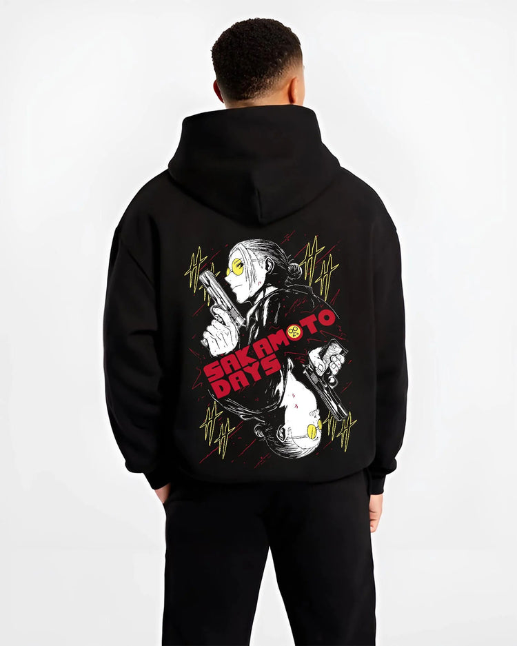 Black hoodie worn by male model from the back featuring Sakamoto Days elite assassin gunfight artwork.