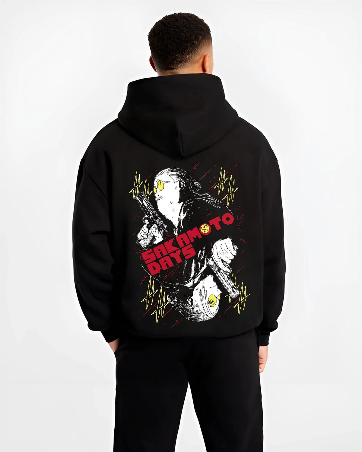 Black hoodie worn by male model from the back featuring Sakamoto Days assassin duo pistol battle artwork.