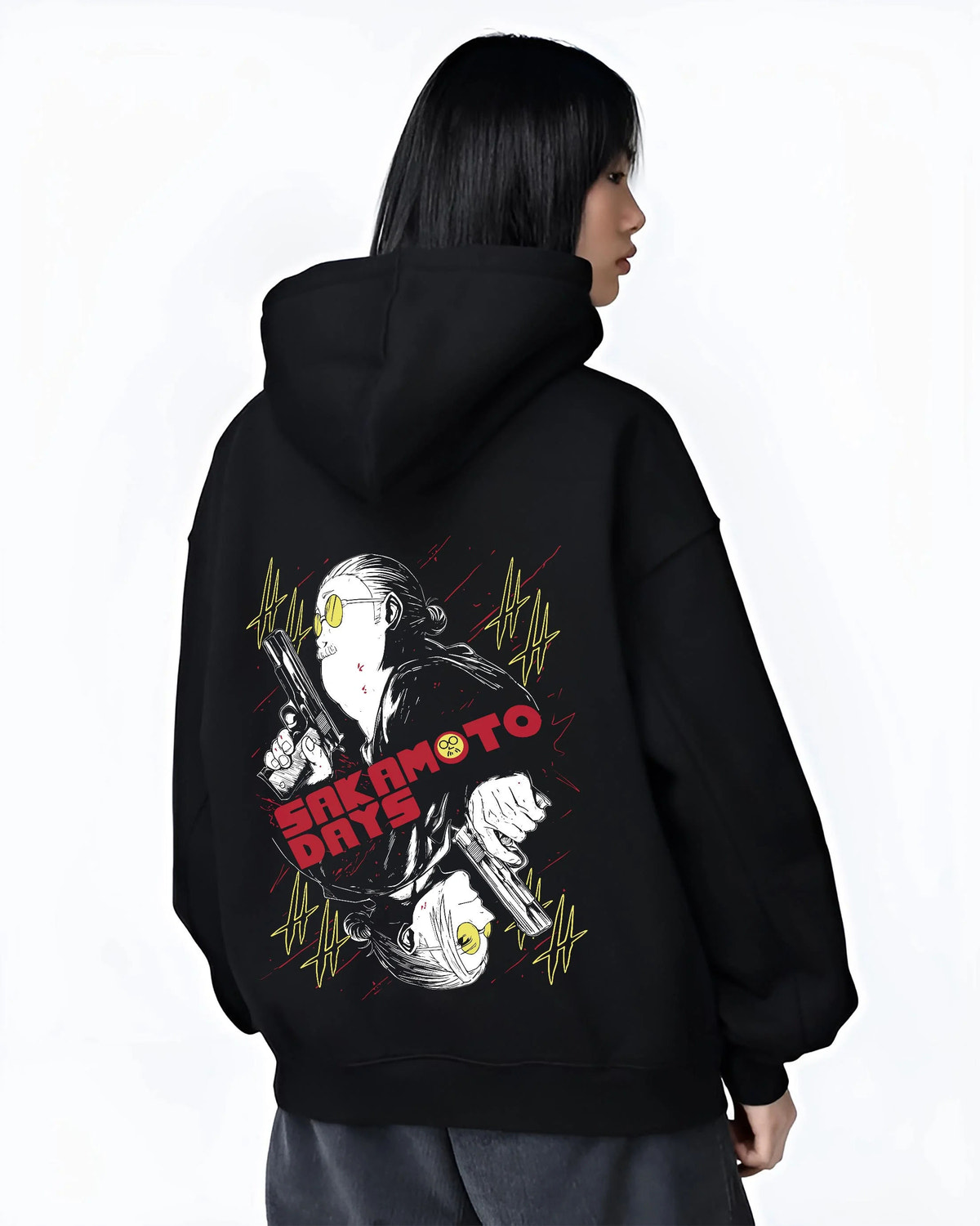Black hoodie worn by female model from the back featuring Sakamoto Days assassin duo pistol battle artwork.