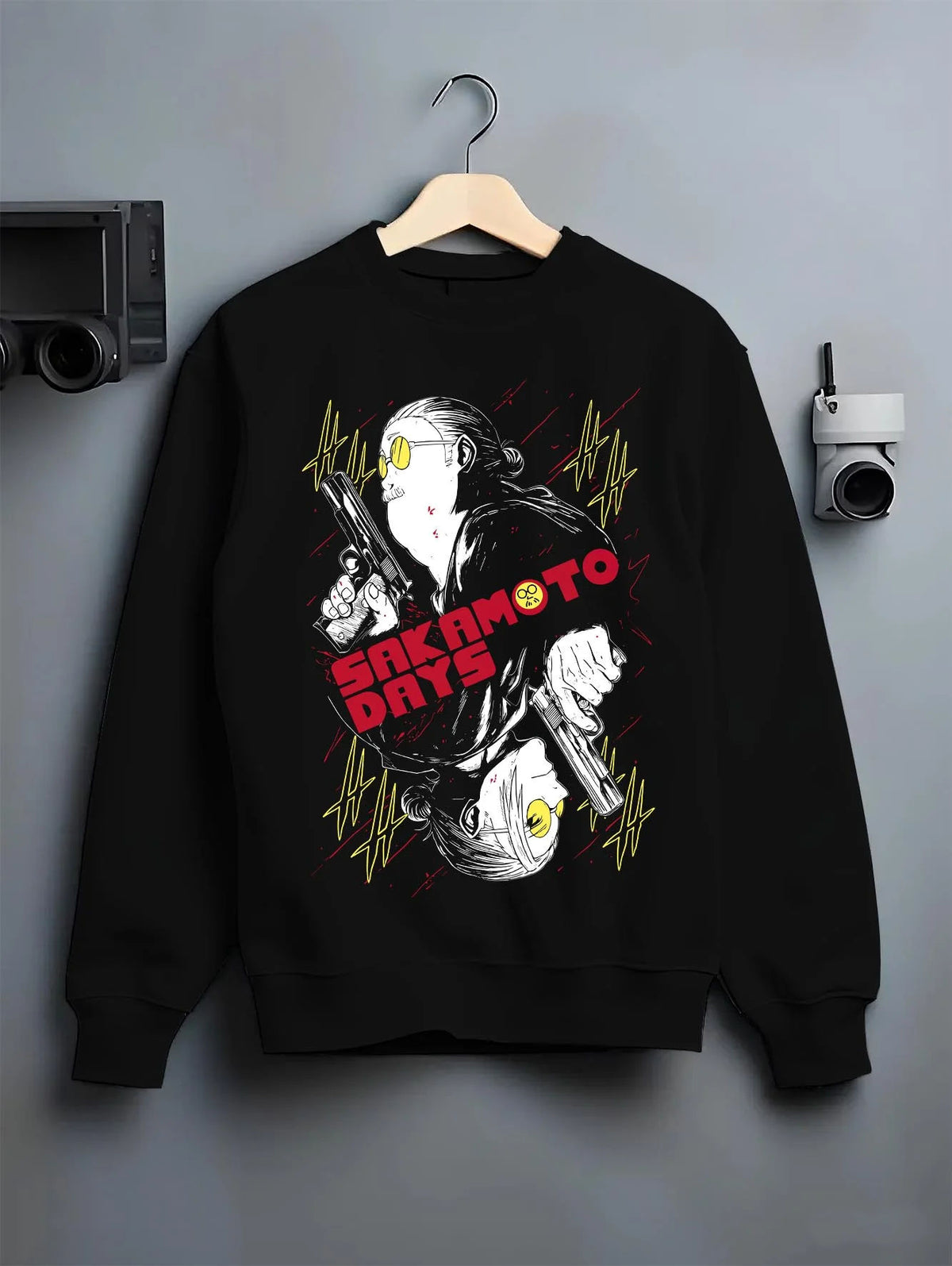 Black crewneck sweatshirt on hanger featuring Sakamoto Days assassin duo pistol battle artwork.