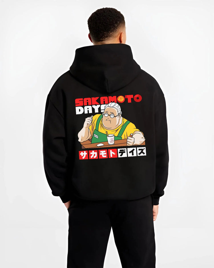 Black hoodie worn by male model from the back featuring Taro Sakamoto golden lion graphic Sakamoto Days artwork.