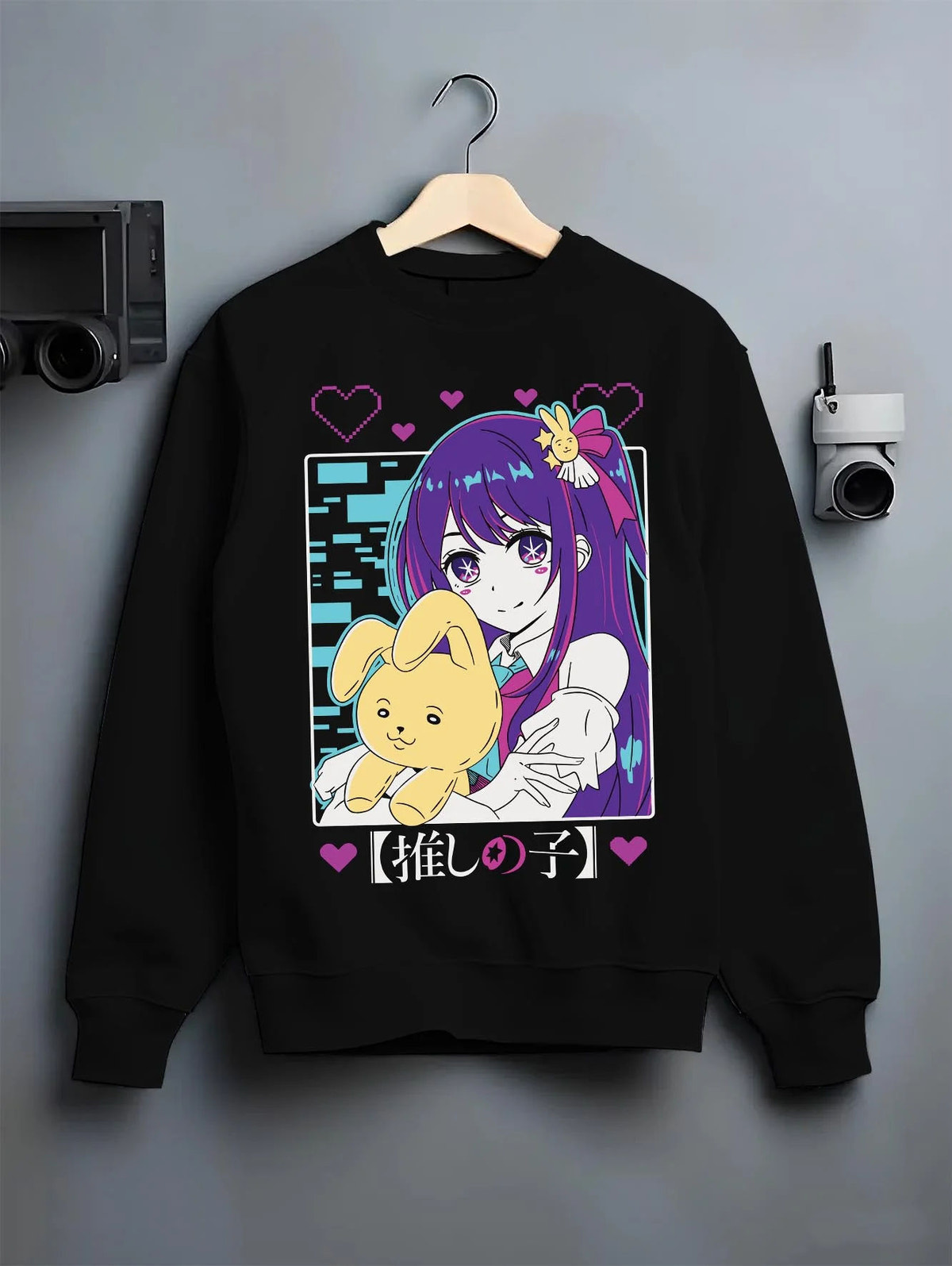 Black crewneck sweatshirt on hanger featuring Ai Hoshino idol star rabbit portrait Oshi no Ko artwork.
