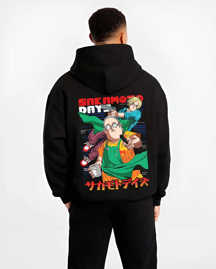 Black hoodie worn by male model from the back featuring Sakamoto Days assassin cast group artwork.