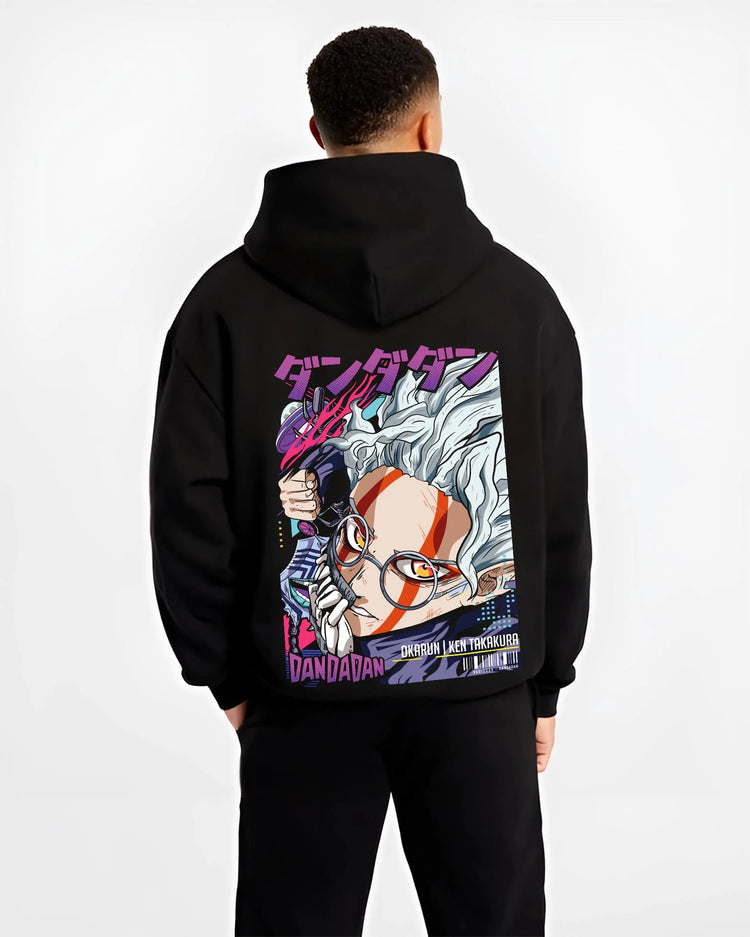 Black hoodie worn by male model, back view with Ken Takakura Hoodie Dandadan Dynamic Fight Scene graphic premium wear.