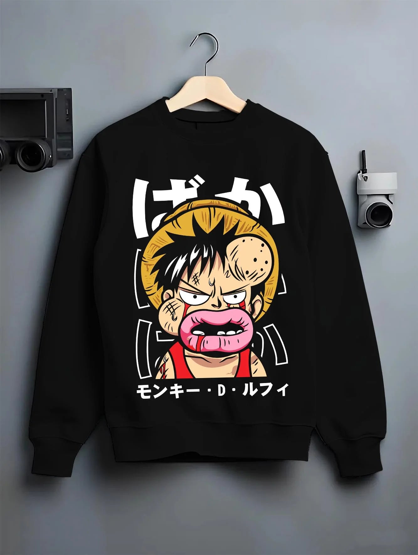 Black crewneck sweatshirt on hanger with Monkey D Luffy Hoodie One Piece Funny Face graphic premium wear.